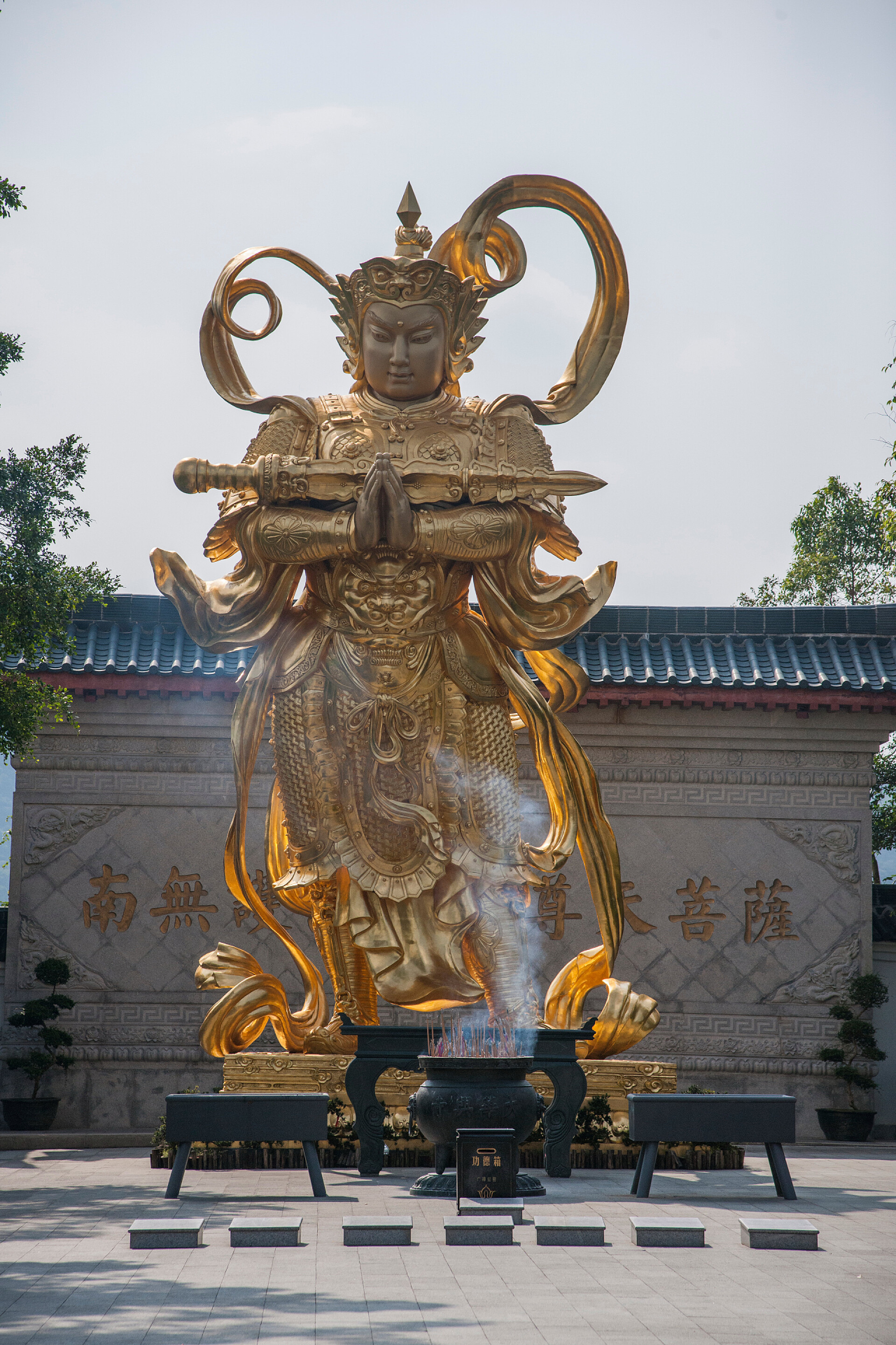 在蓝天下的金色佛像广东省深圳市东部大梅沙华兴寺菩萨韦驮