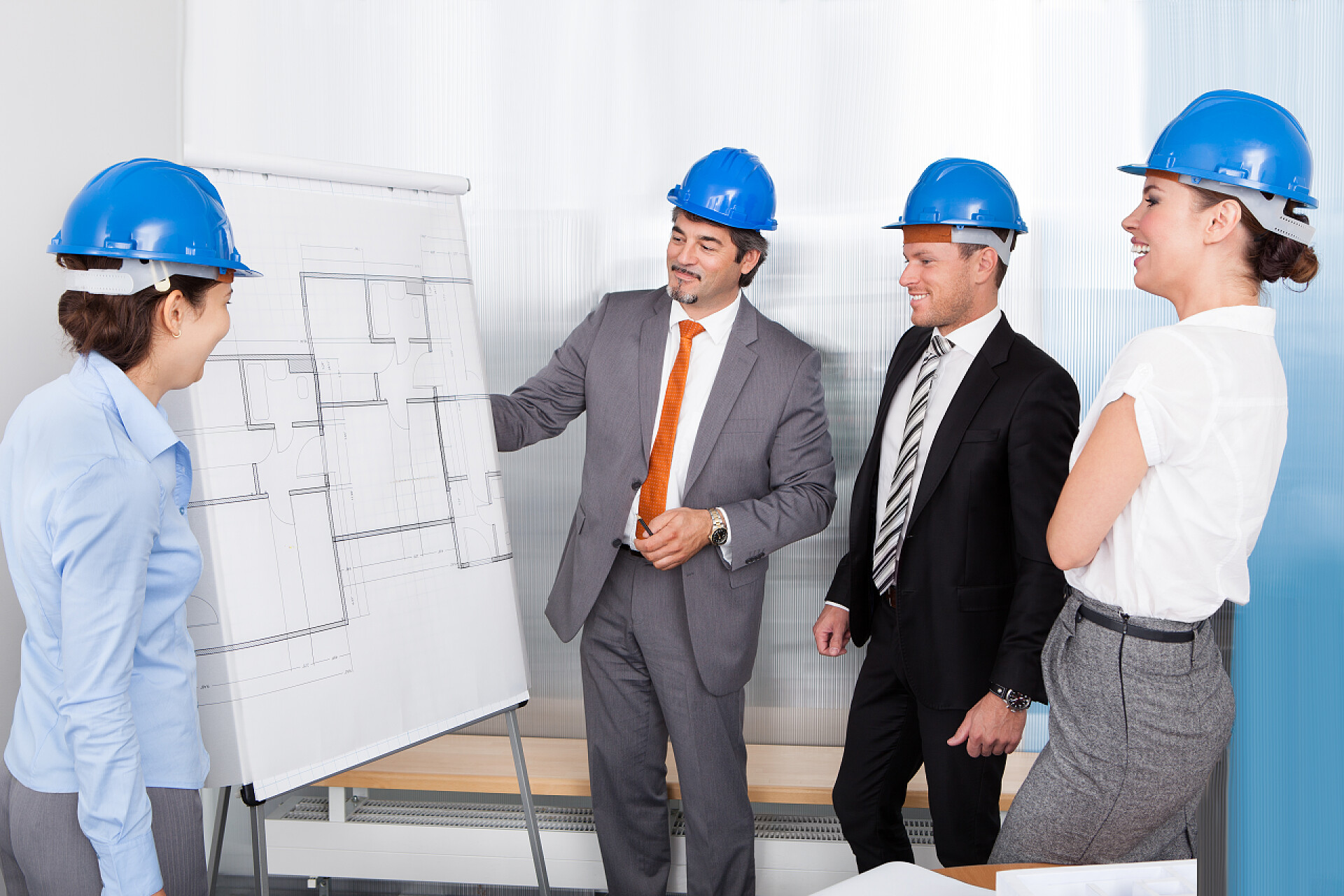 在白色的背景上年轻的工程师讨论图纸讨论计划的建筑师