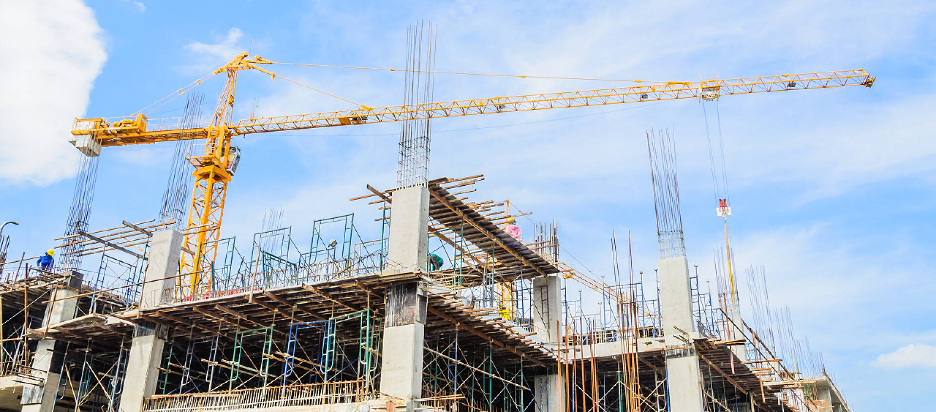 蓝色天空下工作的起重机机器建筑起重机