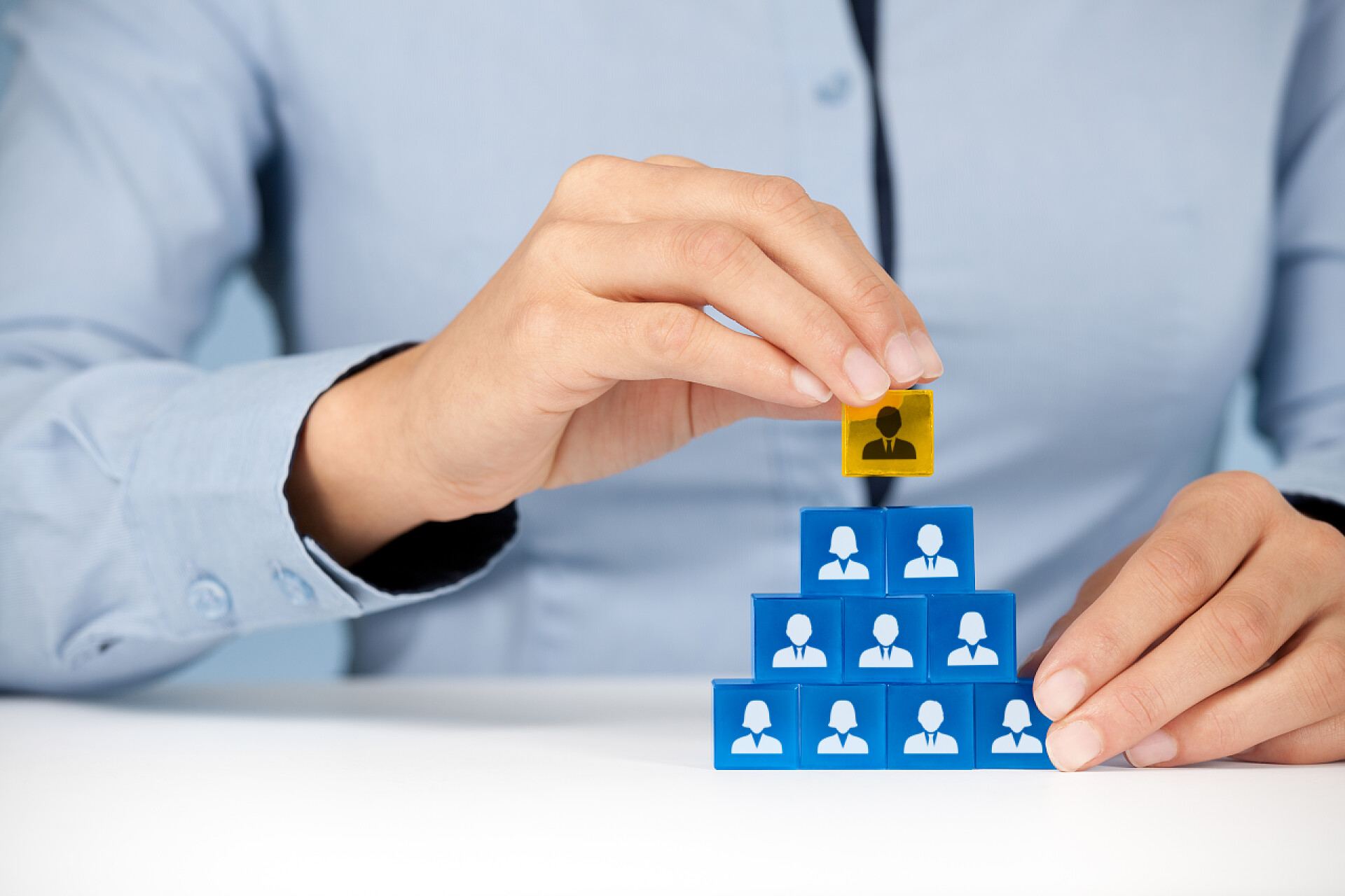 一个年轻的商人手摞人员塔牌