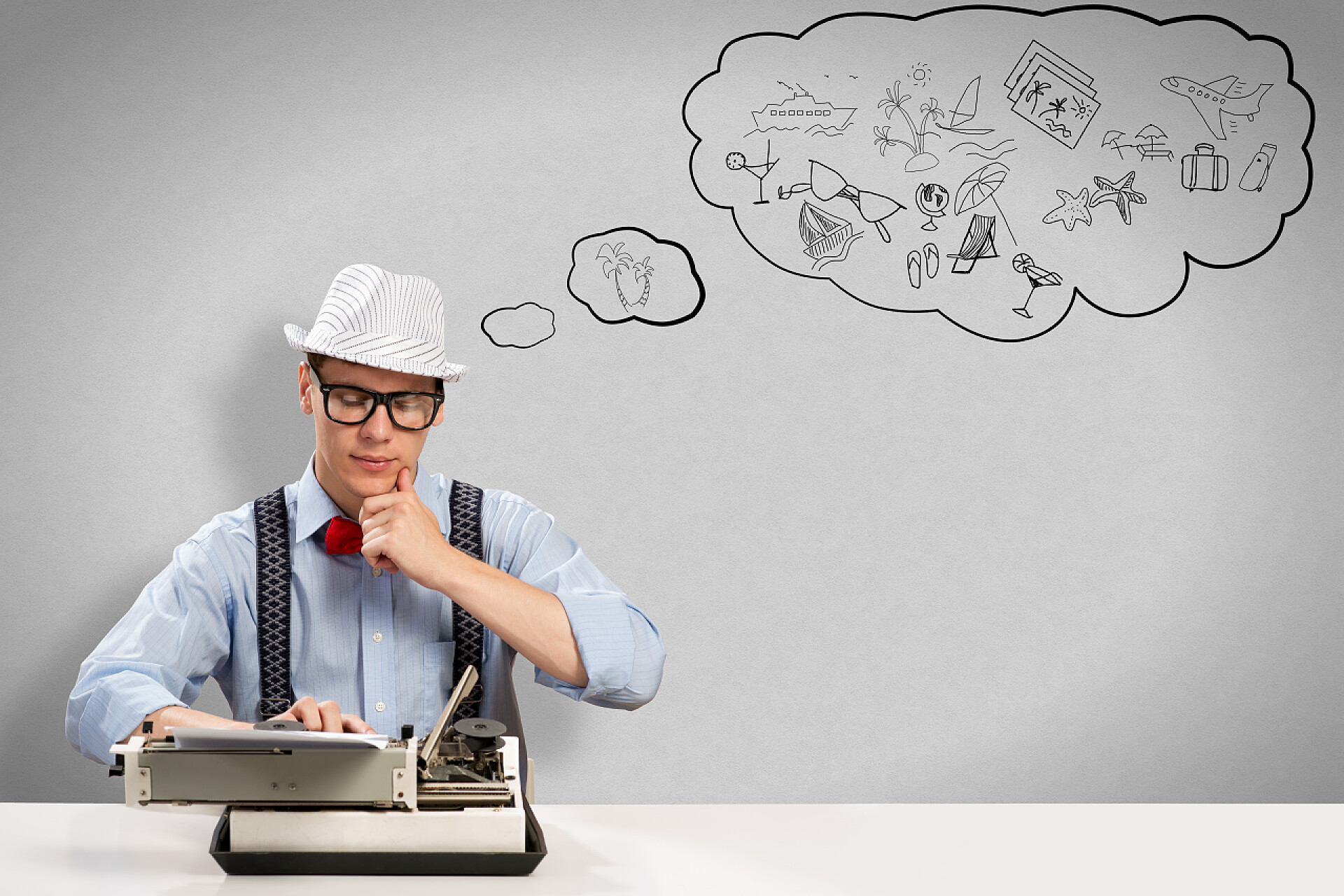 一个年轻记者坐在桌旁打打字机的照片