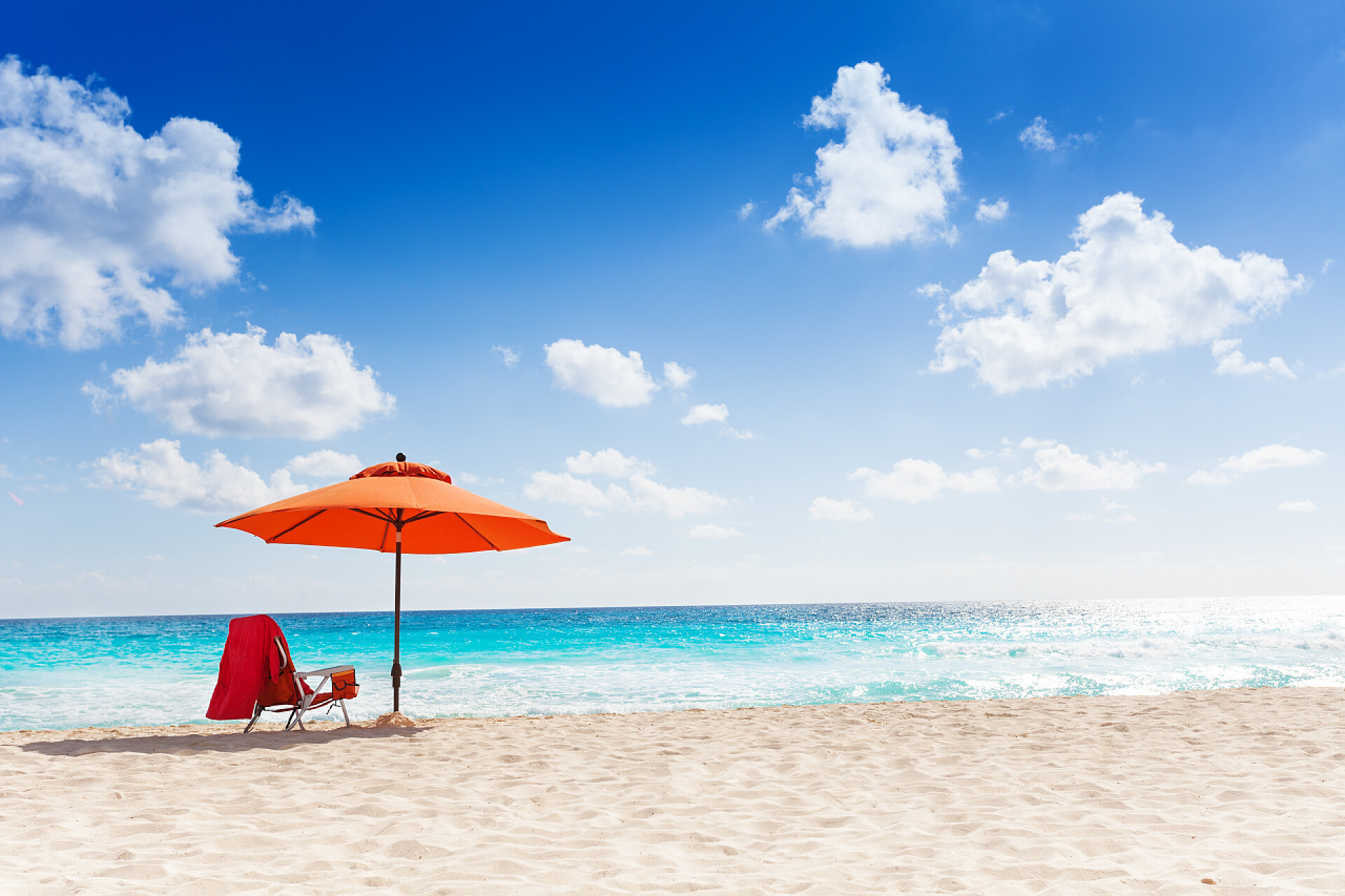 沙滩上橙色的太阳伞和沙滩椅橙色沙滩伞