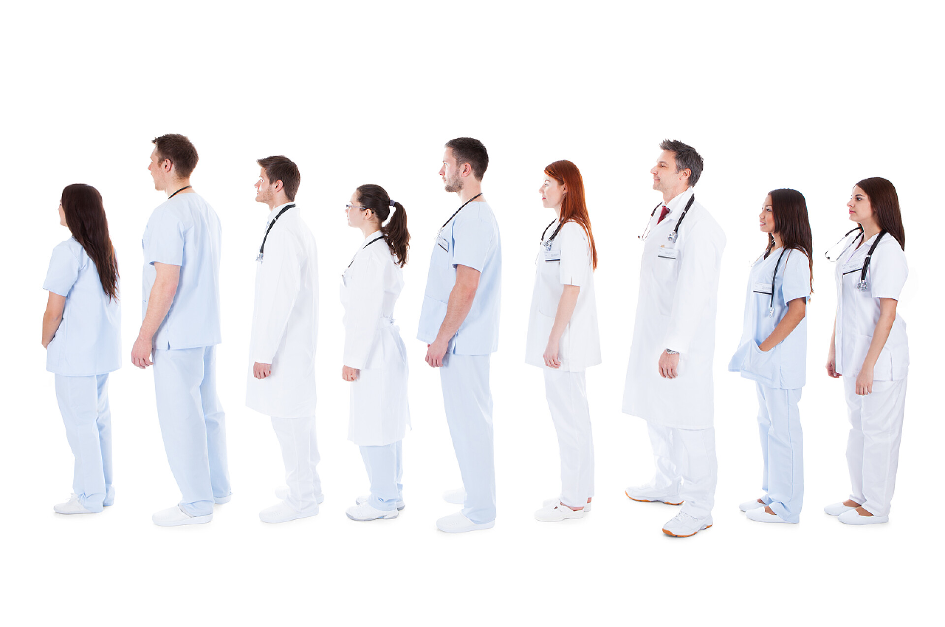 白色背景前排队站立的医务人员大批的医护人员站在队列中