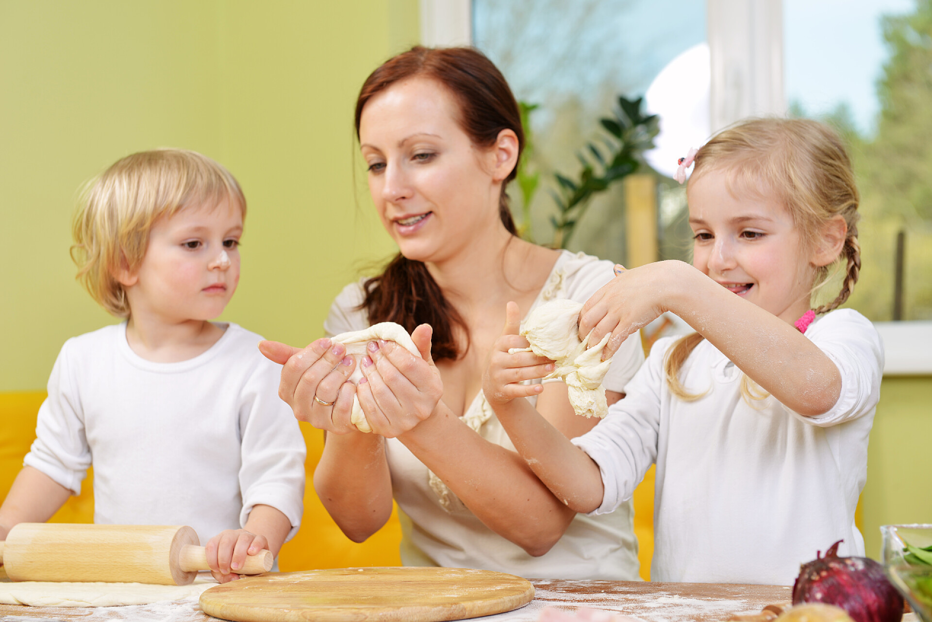母亲带着孩子在做比萨饼有孩子的母亲