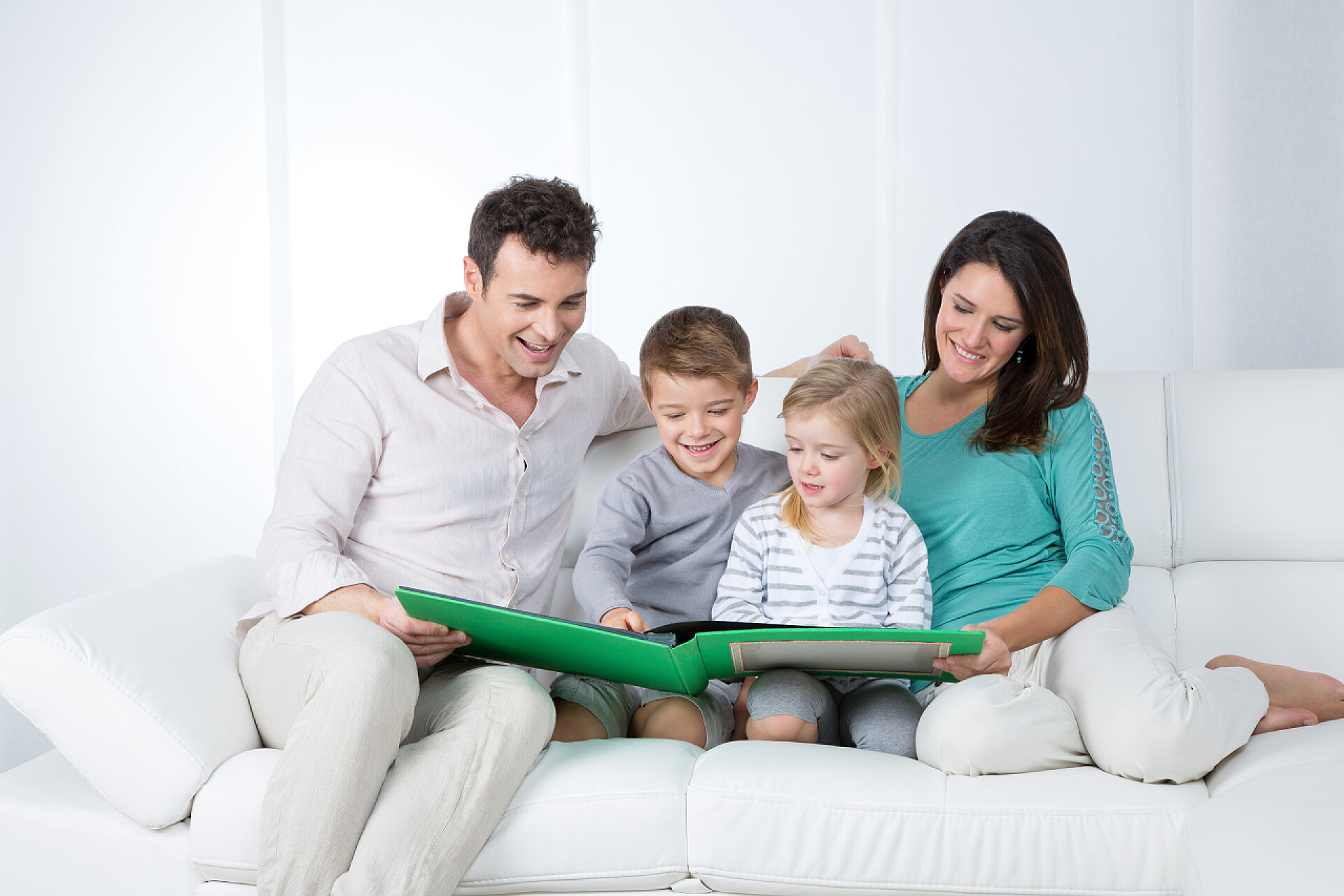 一家四口在沙发上看书父母与子女读书