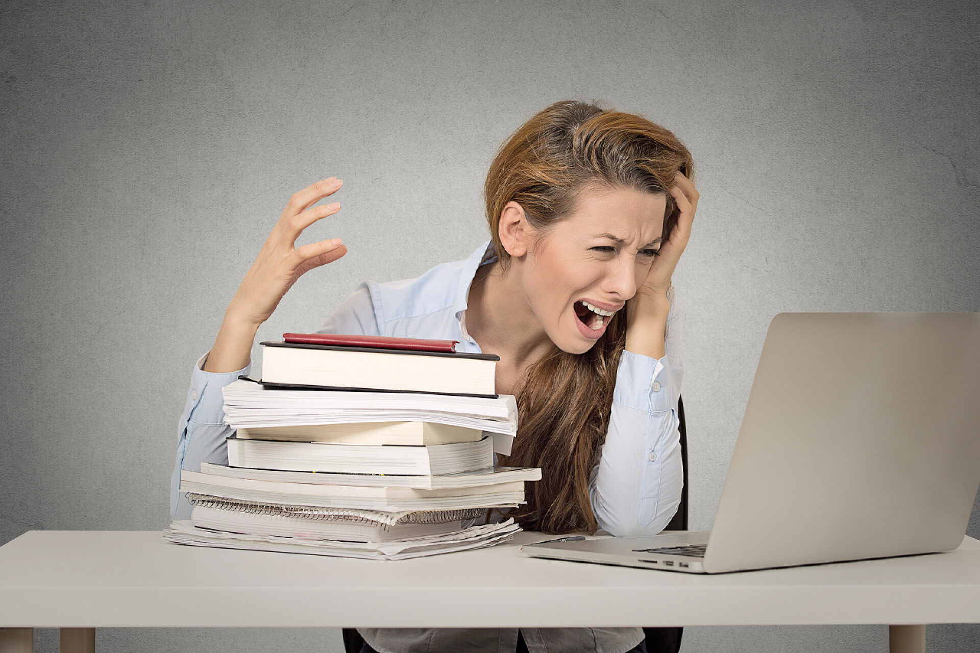 工作中懊恼的女人强调通过研究硬尖叫的女孩 