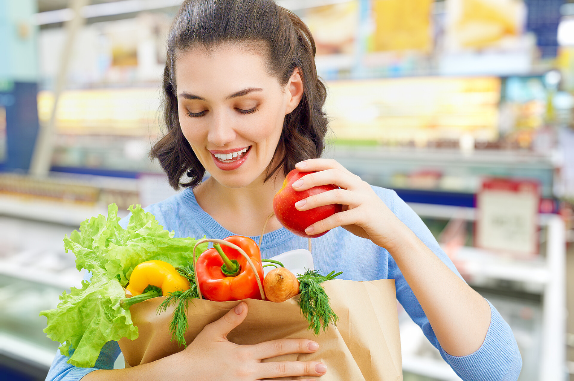 一个女人拿着一袋水果和蔬菜在杂货店