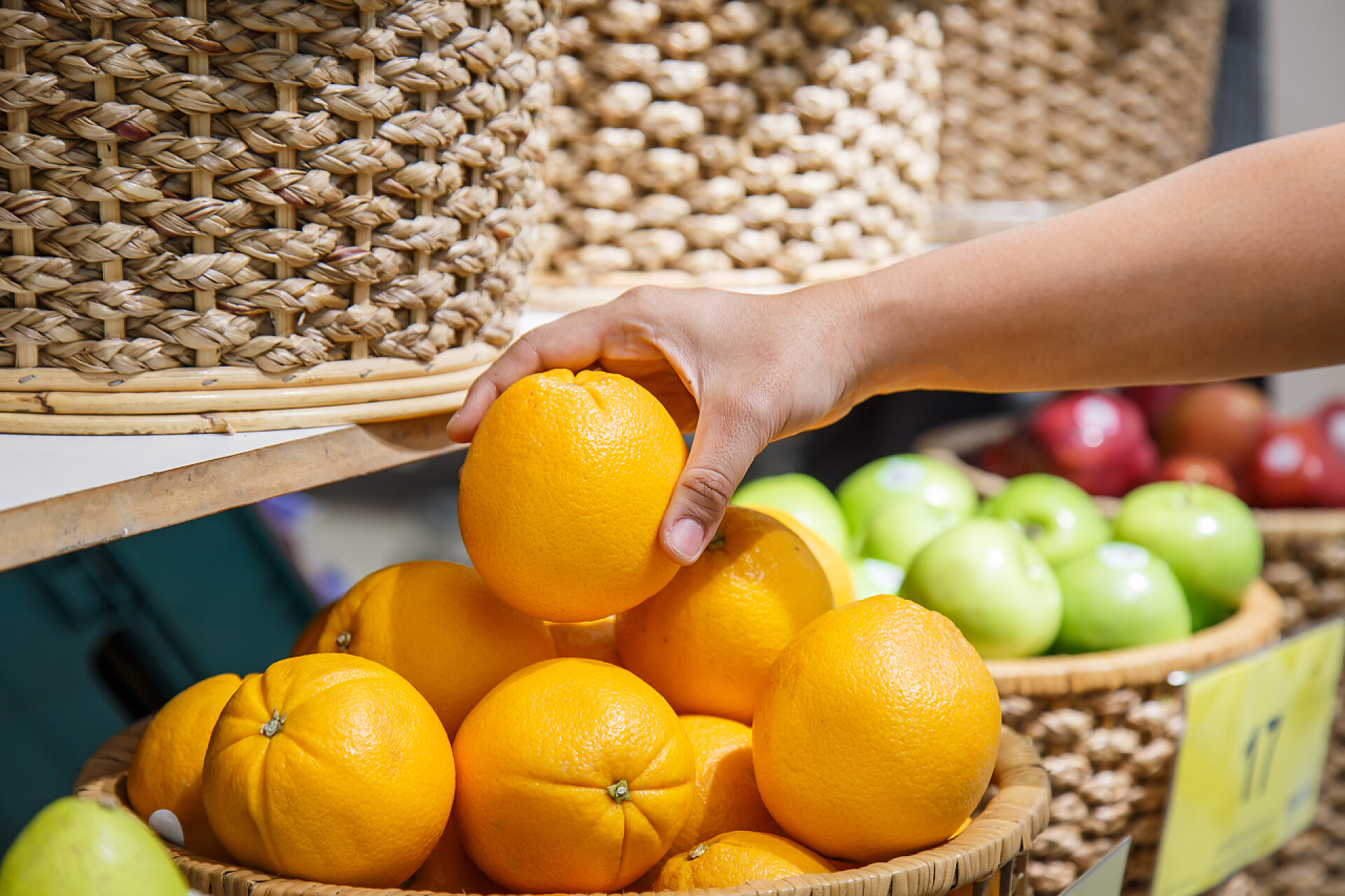 手拿筐中的橙子特写在百货公司内的手橙色