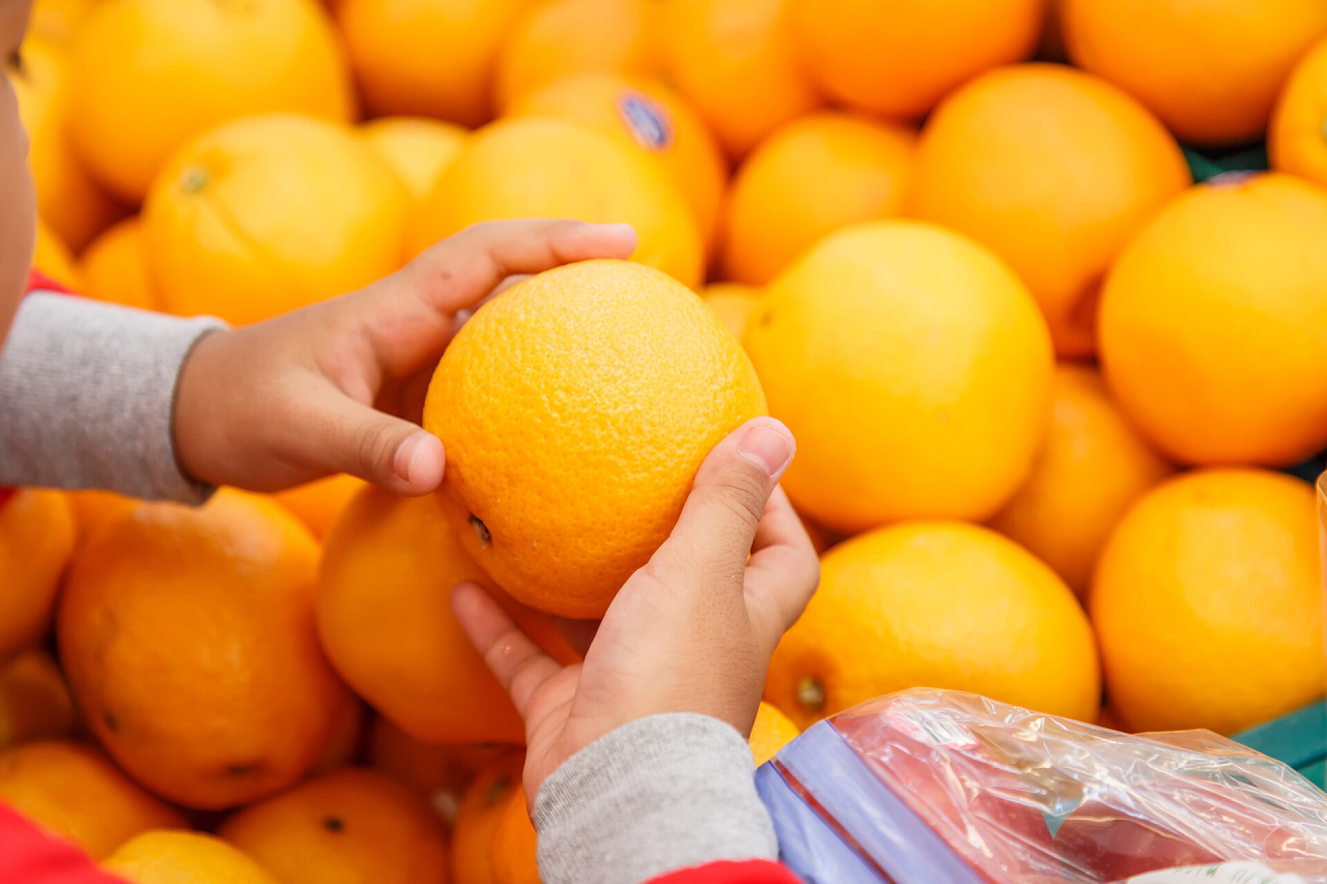 在百货商店挑选橙子水果在百货商店购物的女人
