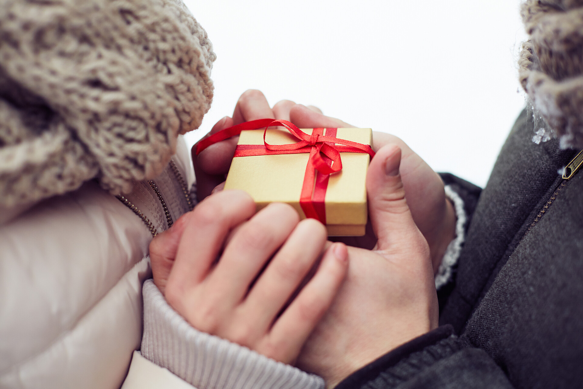 冬天握着礼品的两双手男人给礼物给女朋友