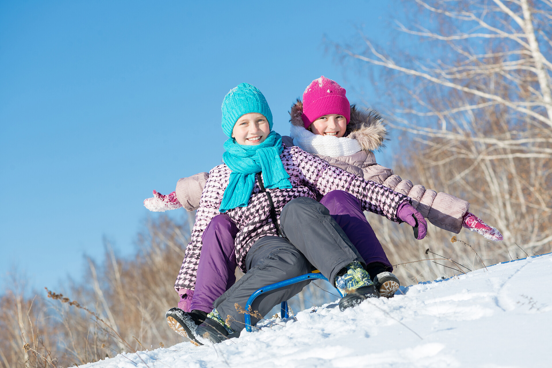 两个可爱的女孩在开心的骑雪橇两个可爱的女孩开心