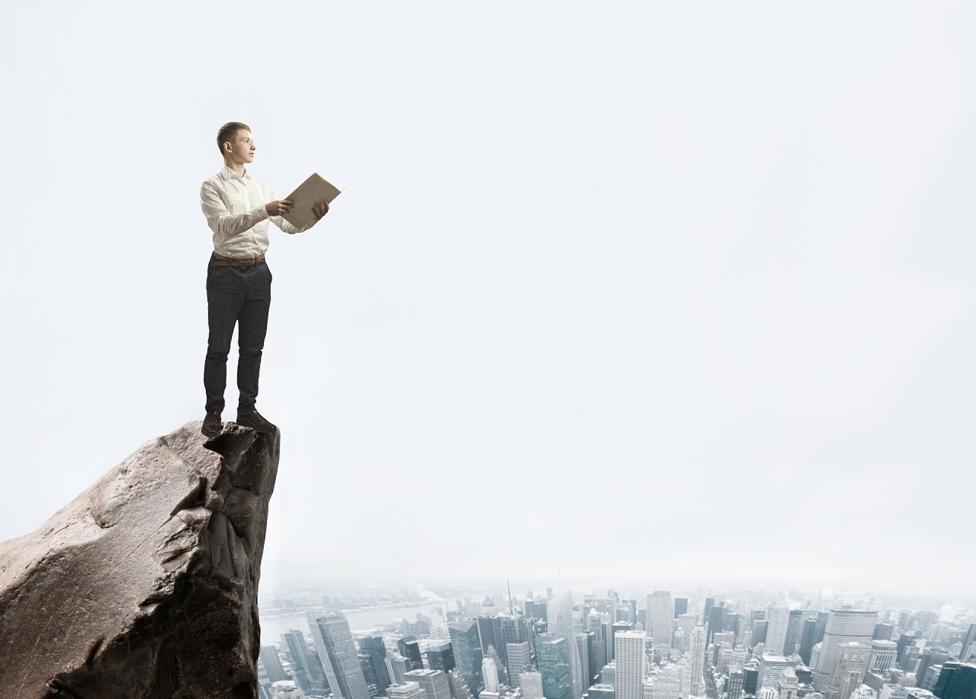 城市背景下在山顶上拿着文件夹的商人在山顶的文件夹上的商人