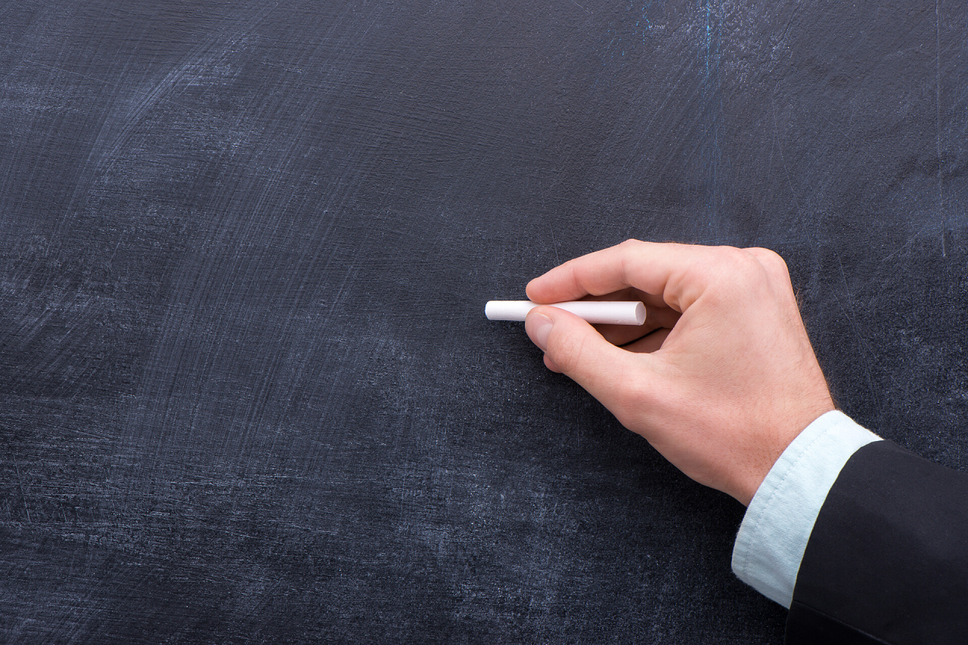 一个男人手里拿着一支白色粉笔Advirtisman 上黑板概念