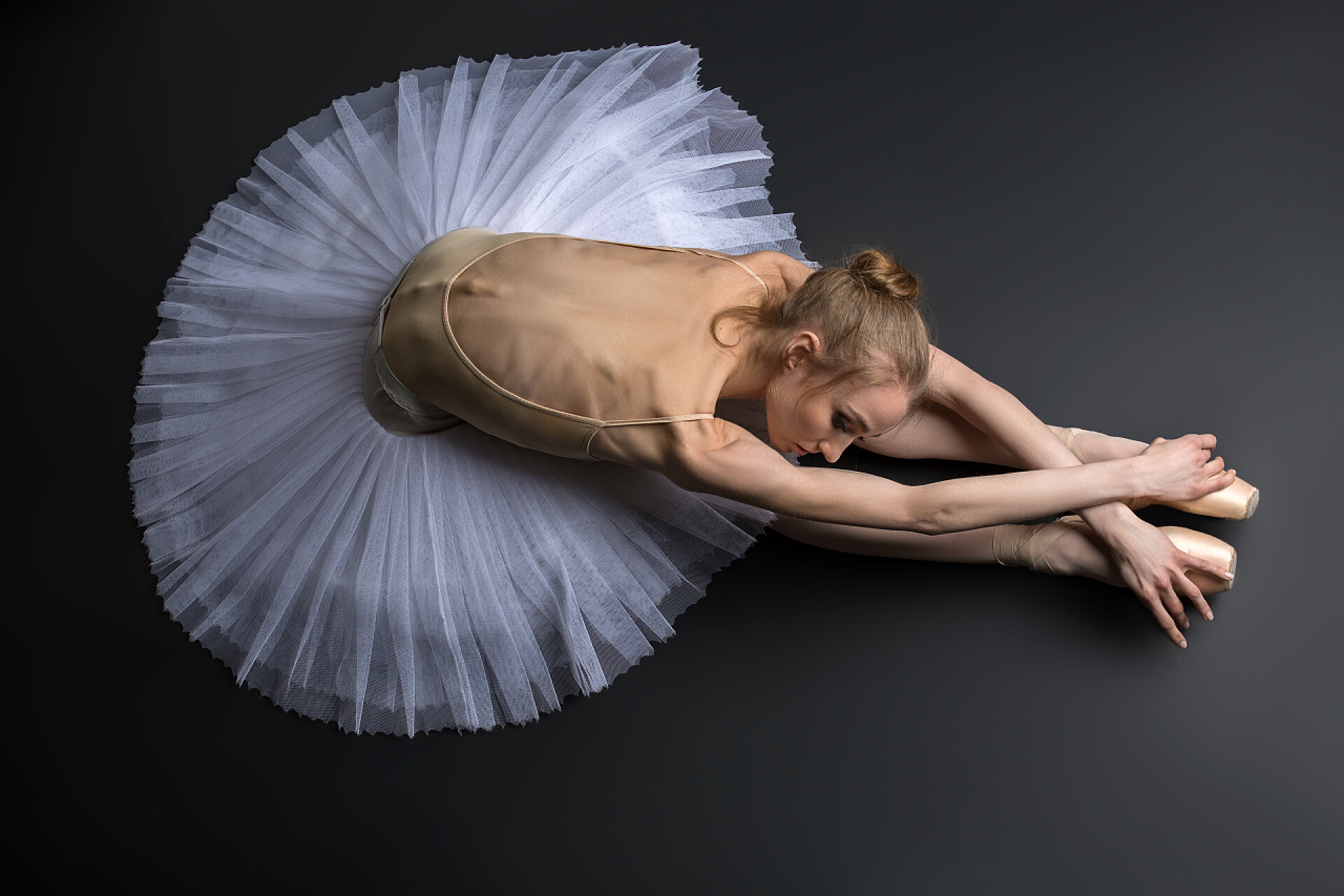 优雅的芭蕾舞演员在黑色地板上表演优雅的芭蕾舞演员