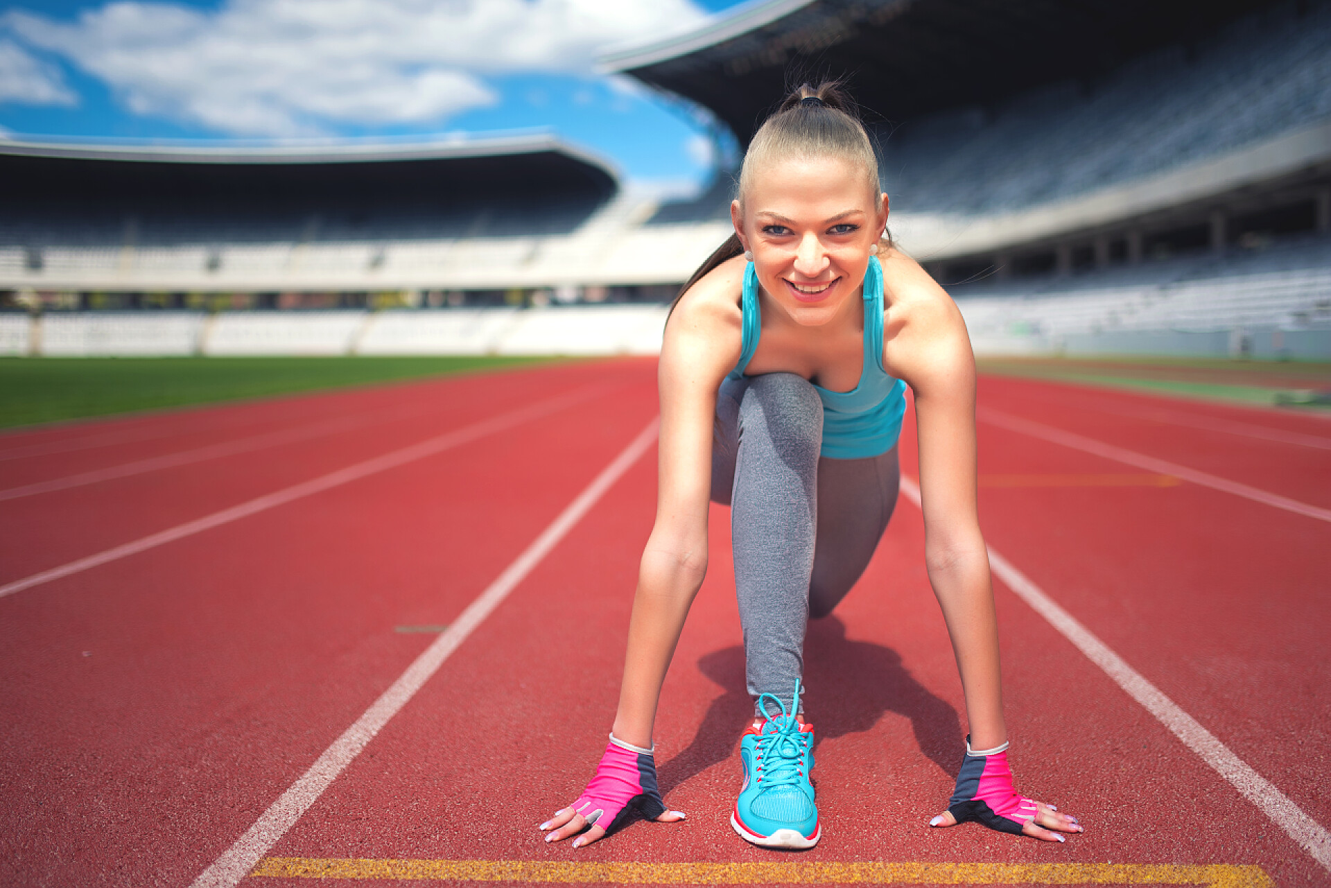 一位女子赛跑运动员在体育馆赛道上准备起跑积极的女子赛跑运动员准备田径比赛，享受锻炼，培养和锻炼。在体育场跑道上慢跑健身女孩。Instagram 滤镜效果