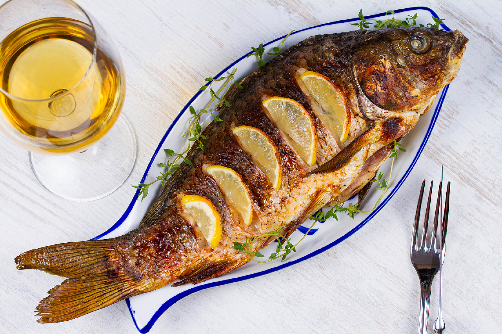 烤全鱼配沙拉和柠檬烤全鱼鲤鱼配沙拉和柠檬;杯酒