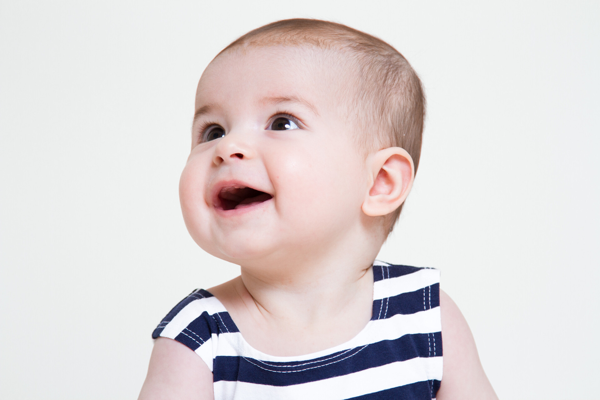 白色背景一个宝宝抬头微笑美丽微笑的可爱的小宝贝女孩画像