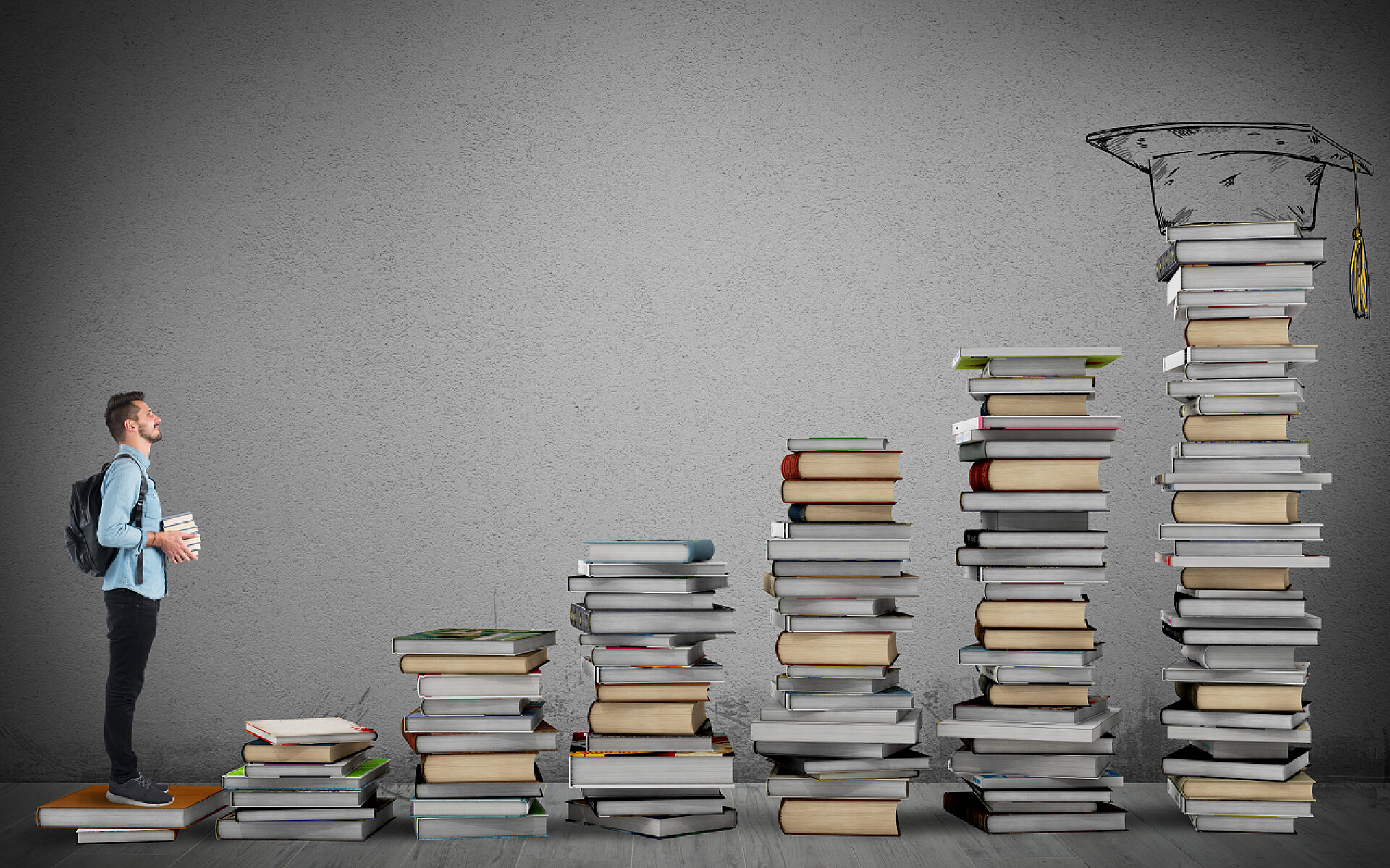 灰色背景学生踩着书本铺就的台阶往上爬学生研究的往上爬