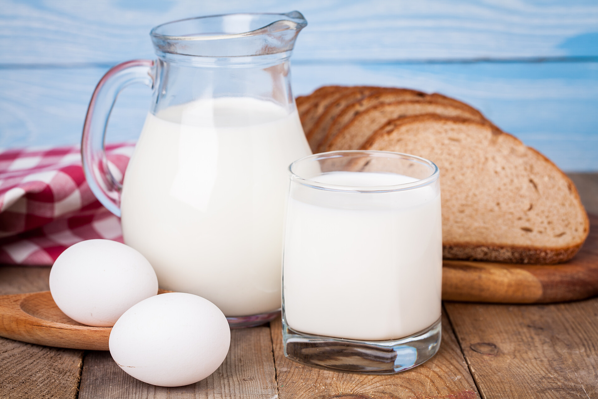 木桌上的营养早餐面包、 鸡蛋和牛奶杯木制的桌子上