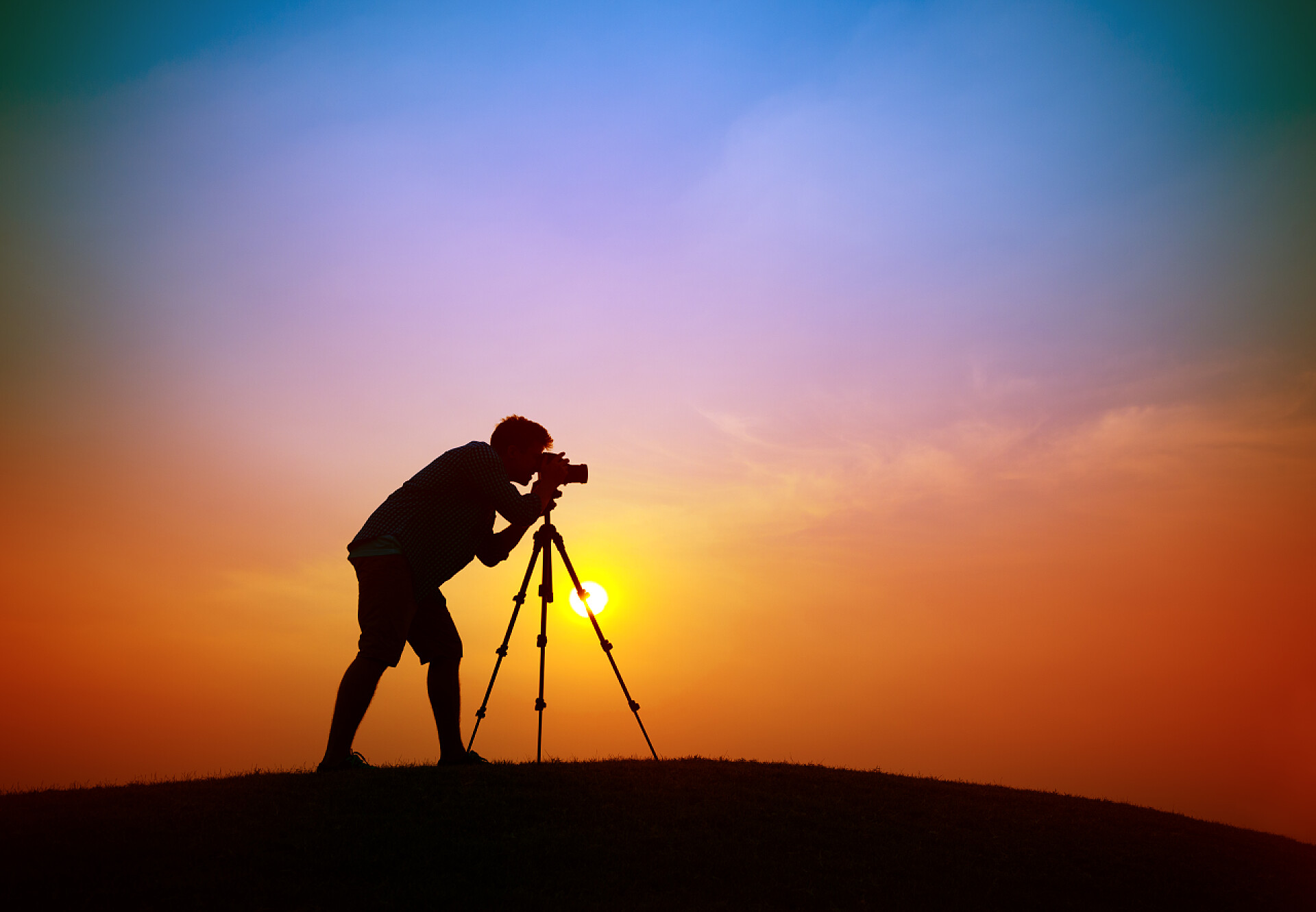 摄影师在户外拍摄日出剪影摄影师的相机拍摄概念