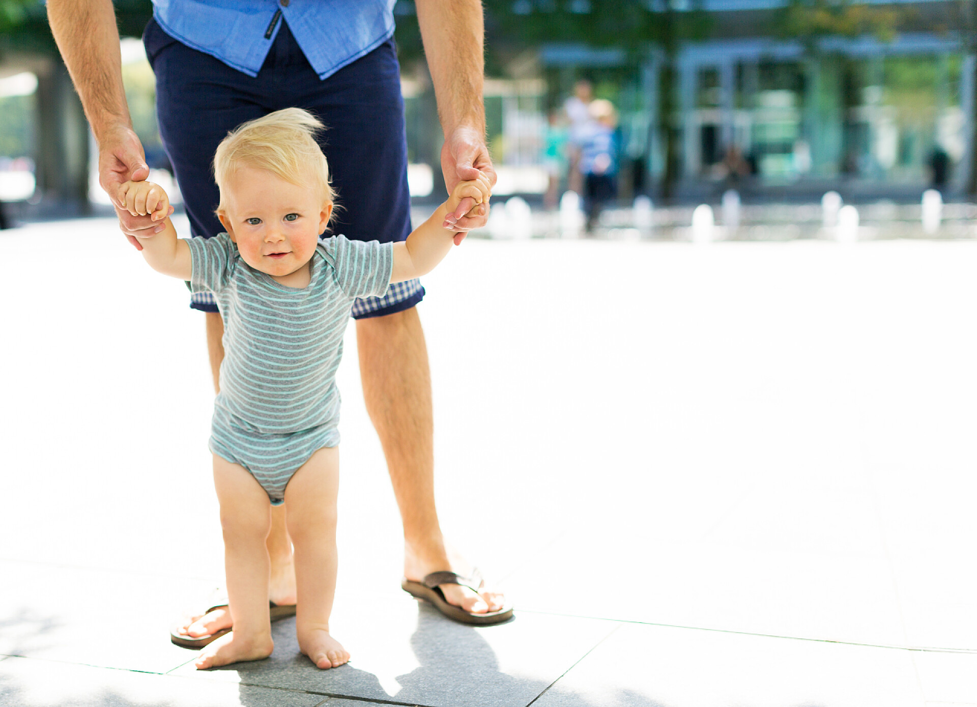 父亲带着小男孩学走路与父亲一起迈出第一步的婴儿会有所帮助