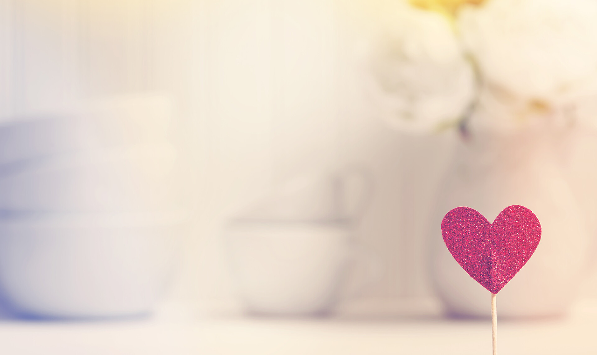 模糊背景上的小红心白瓷碟子和鲜花小小的心里，与白瓷餐具