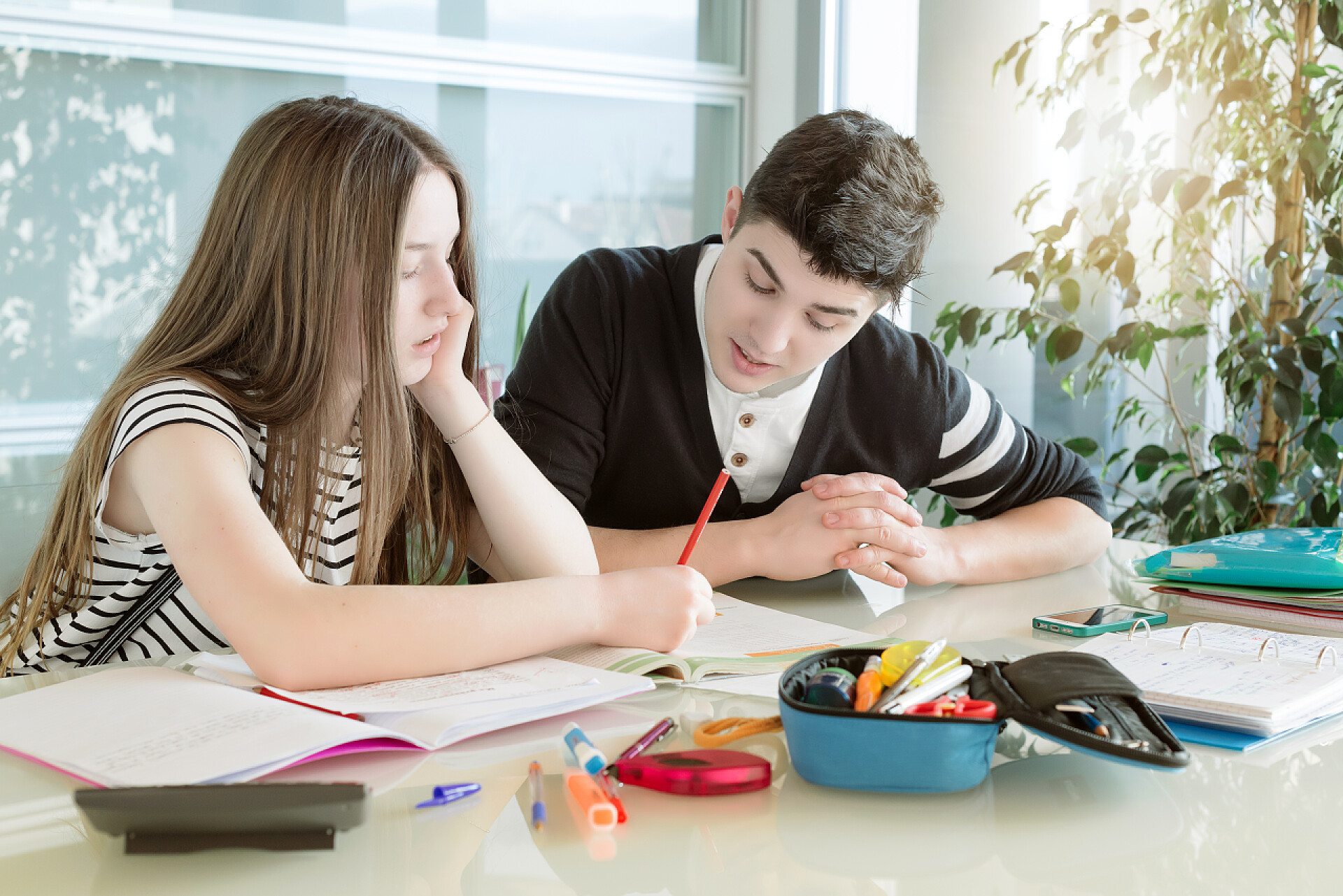 哥哥帮助她妹妹做功课年轻的弟弟和妹妹