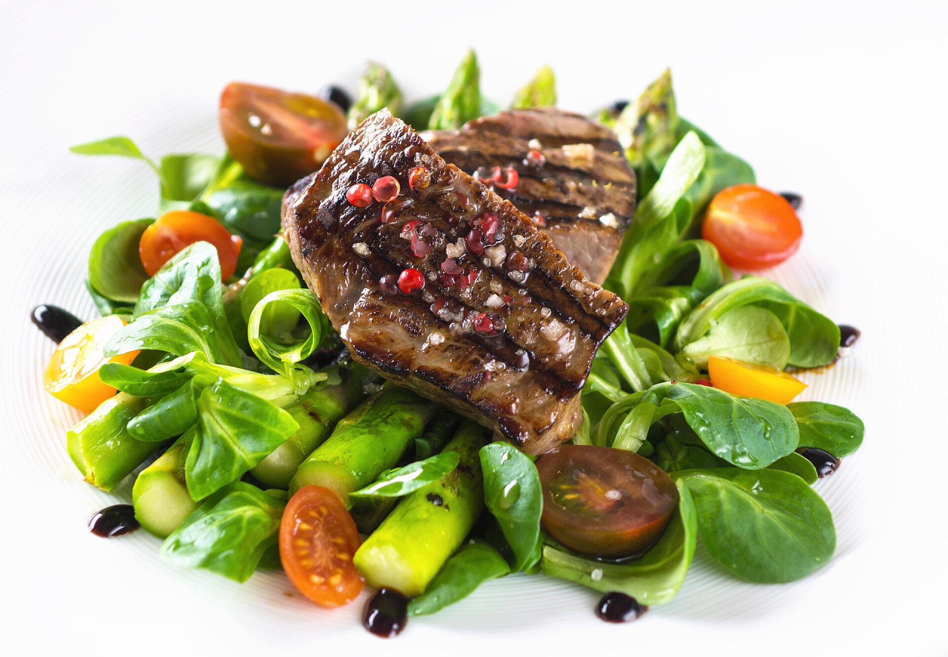 白色背景上的烤牛排牛排配烤芦笋 