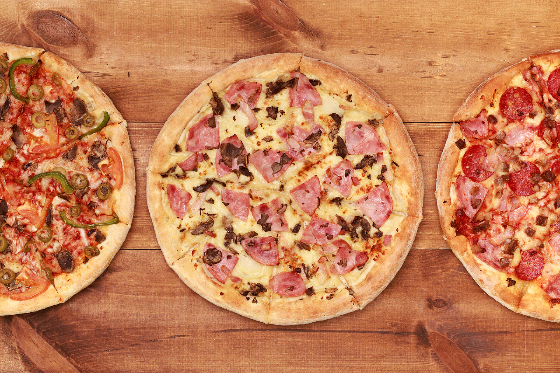 顶视图的三个美味比萨饼桌上的三个美味披萨 