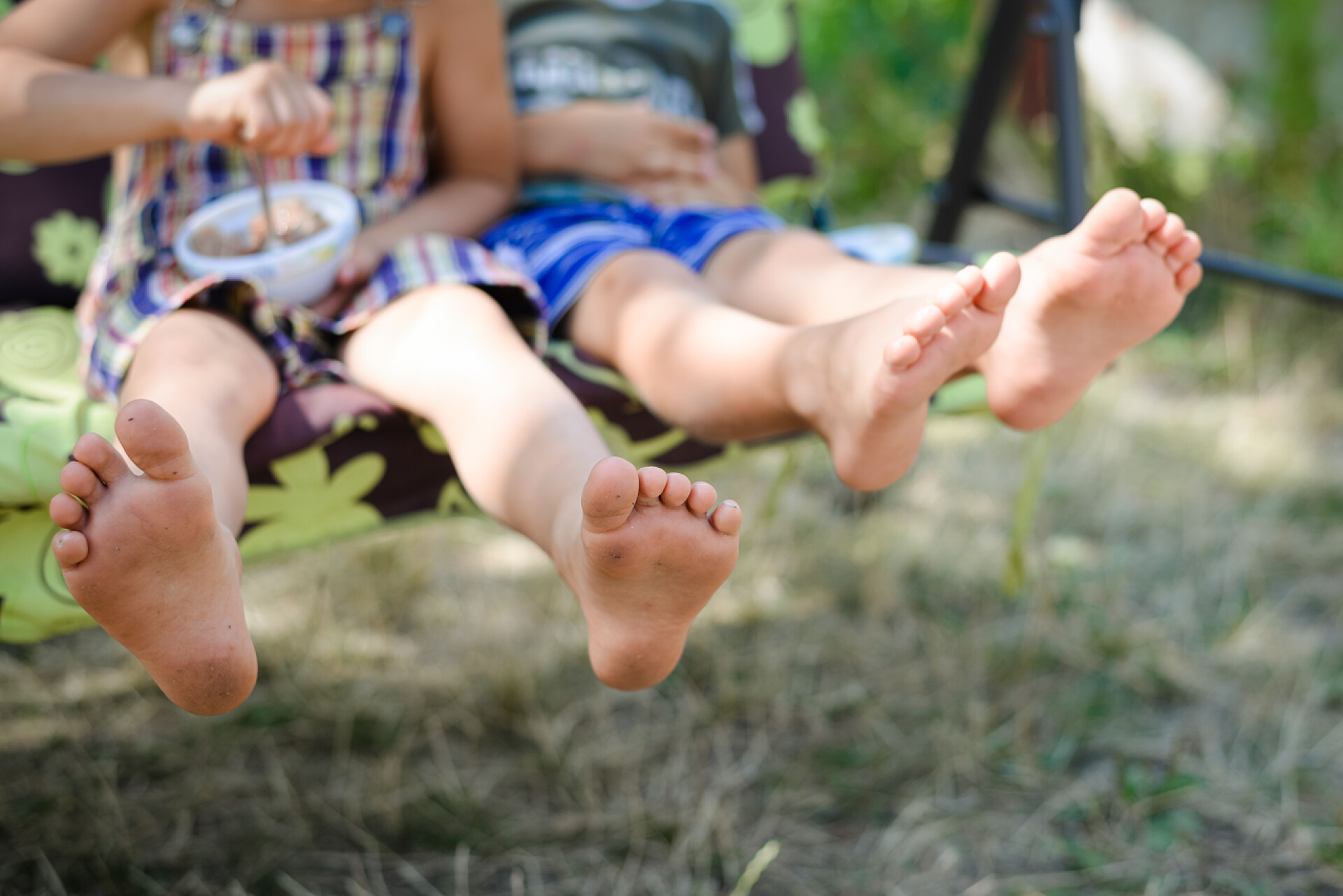 荡秋千的快乐孩子快乐的孩子坐和阳光普照农村背景荡秋千的特写.