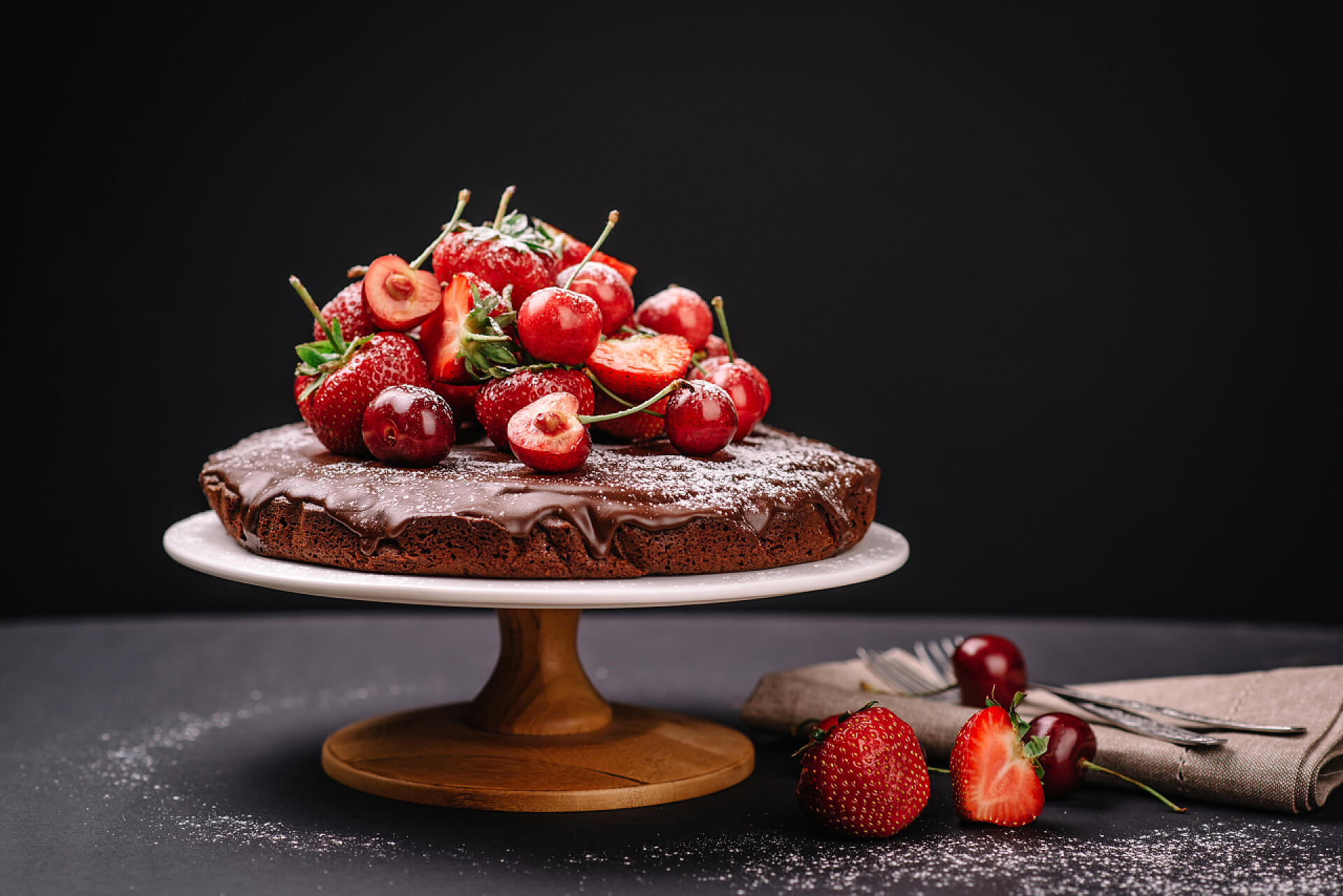 桌子上的巧克力蛋糕有草莓和樱桃等水果托斯卡纳的巧克力蛋糕，草莓和樱桃