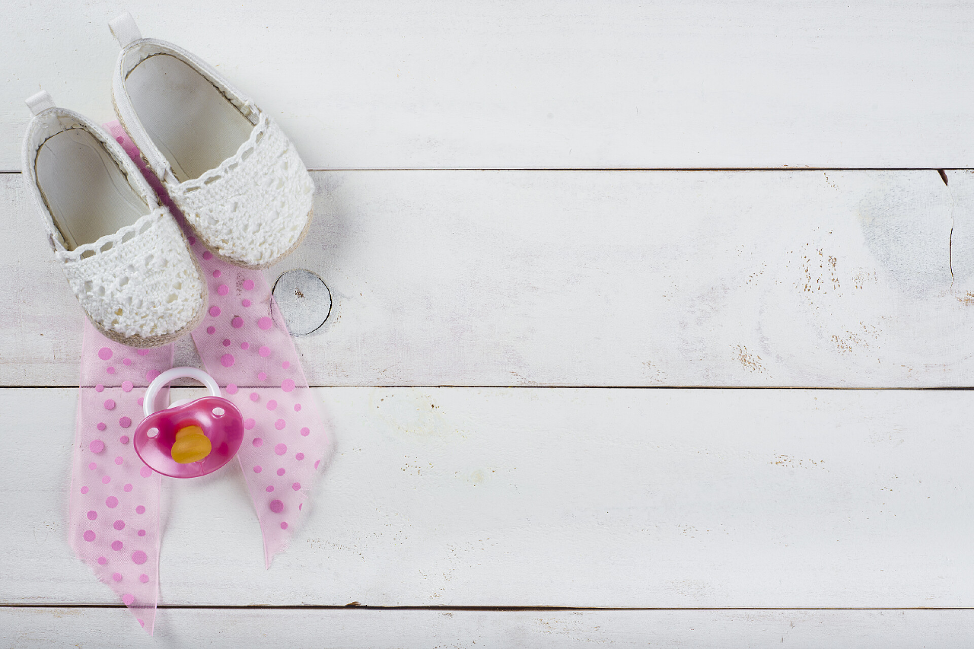 俯拍白色木板上放着鞋子和奶嘴婴儿配图期待着一个婴儿背景