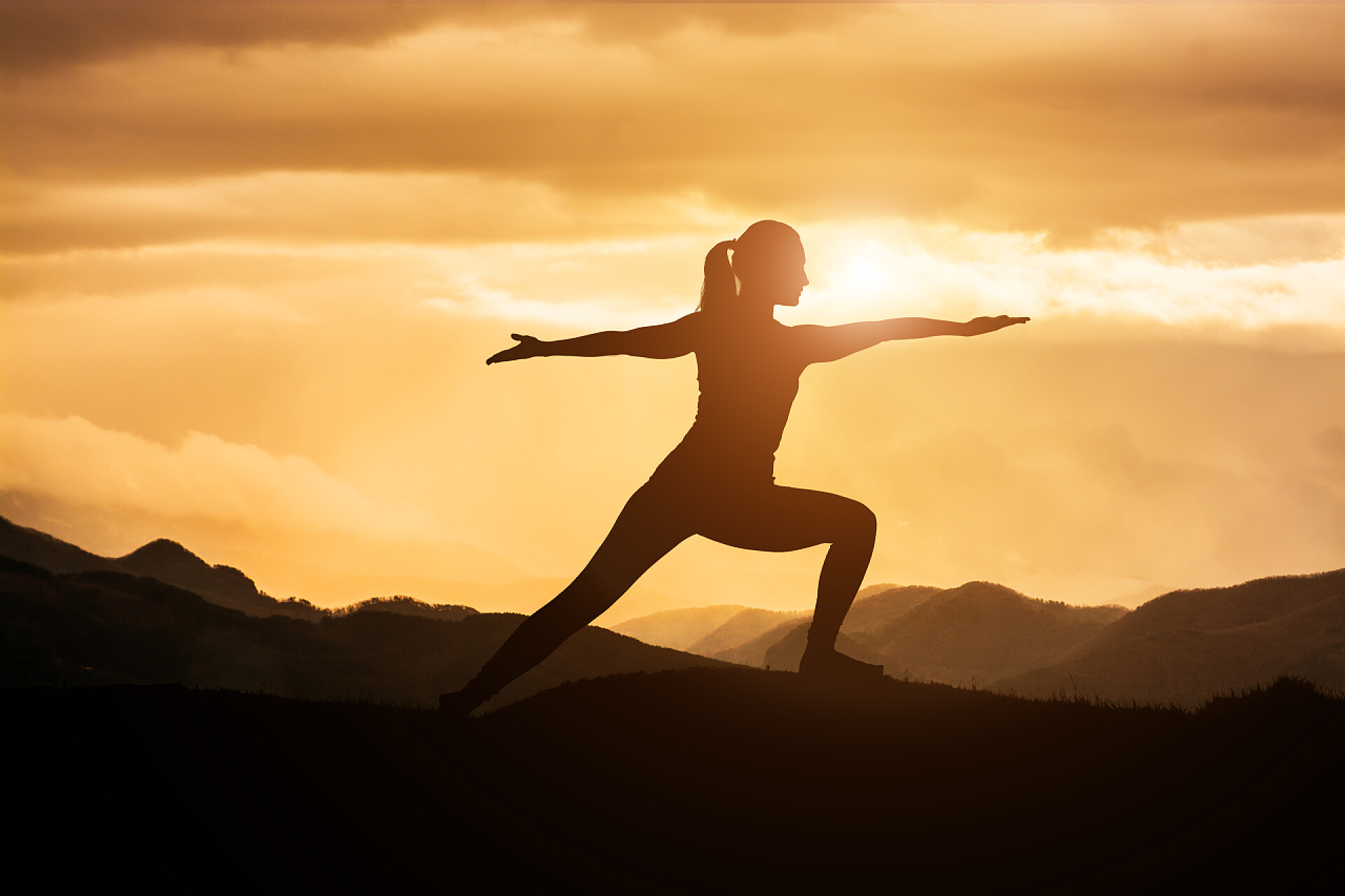 一名年轻女子练习瑜伽日落健身配图年轻的亚裔女子练习瑜伽战士在日落时