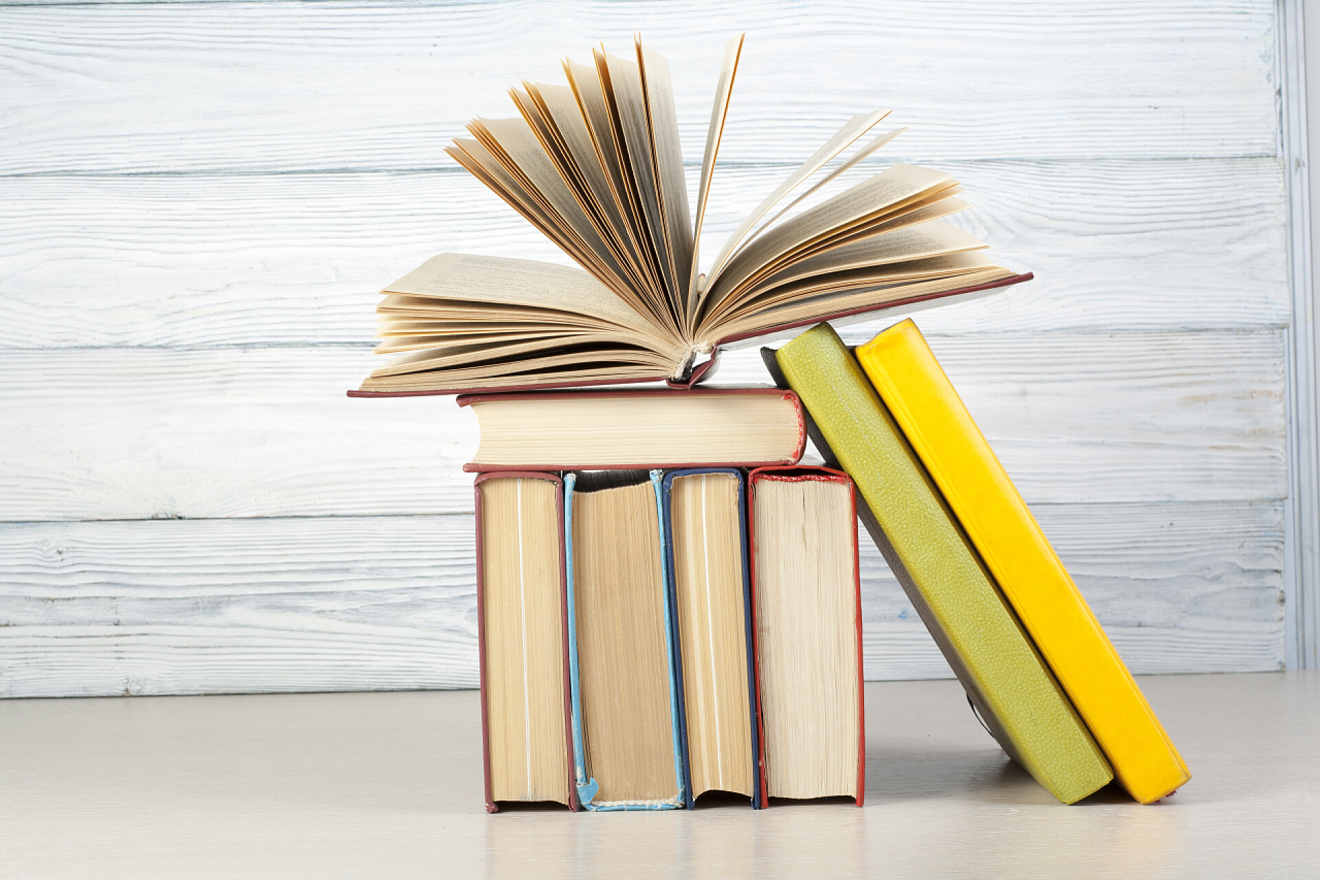 堆放在一起的书籍打开的书，精装书木制的桌子上。教育背景。回到学校。复制文本的空间.