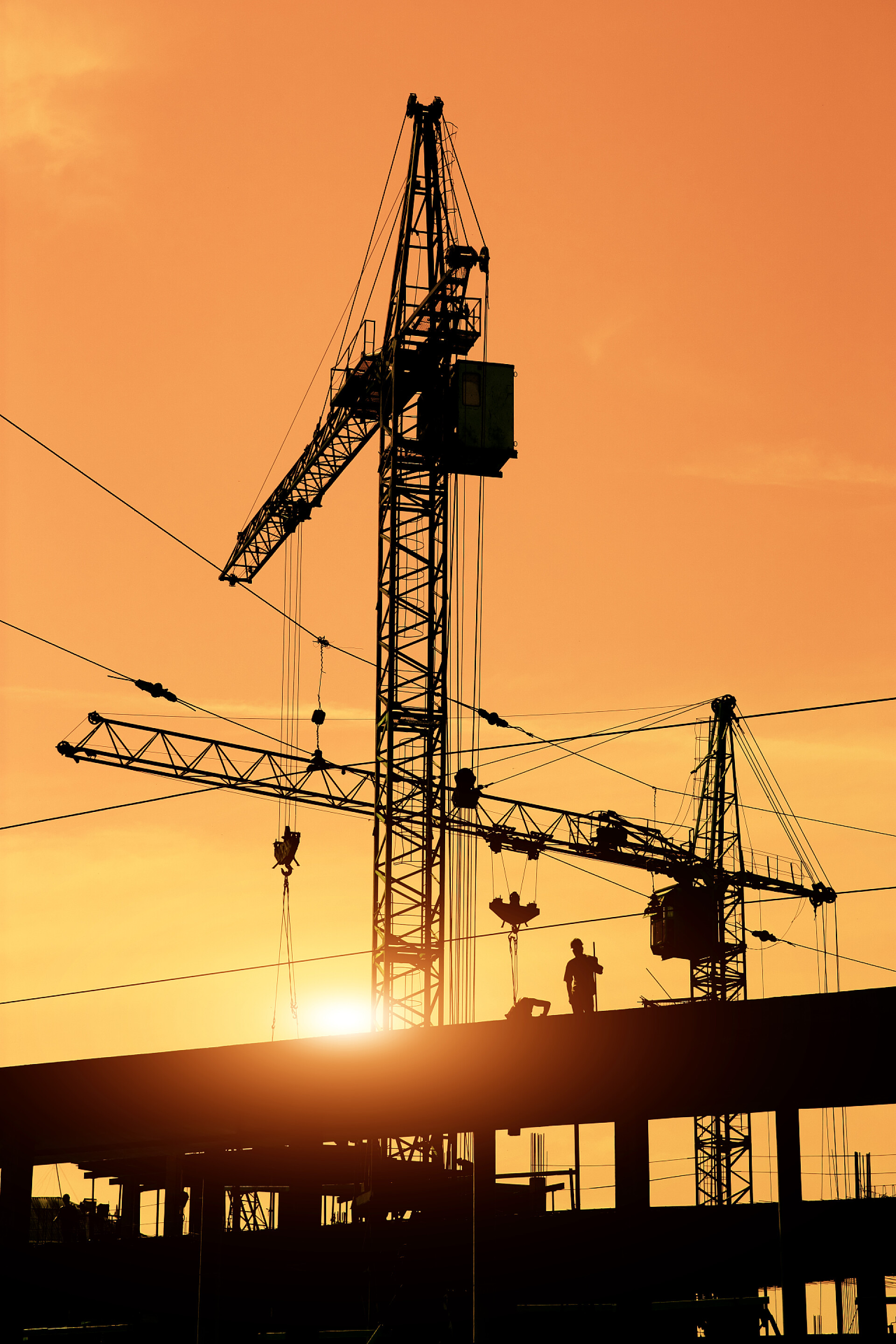 两个建筑起重机和在现场的施工人员货柜码头