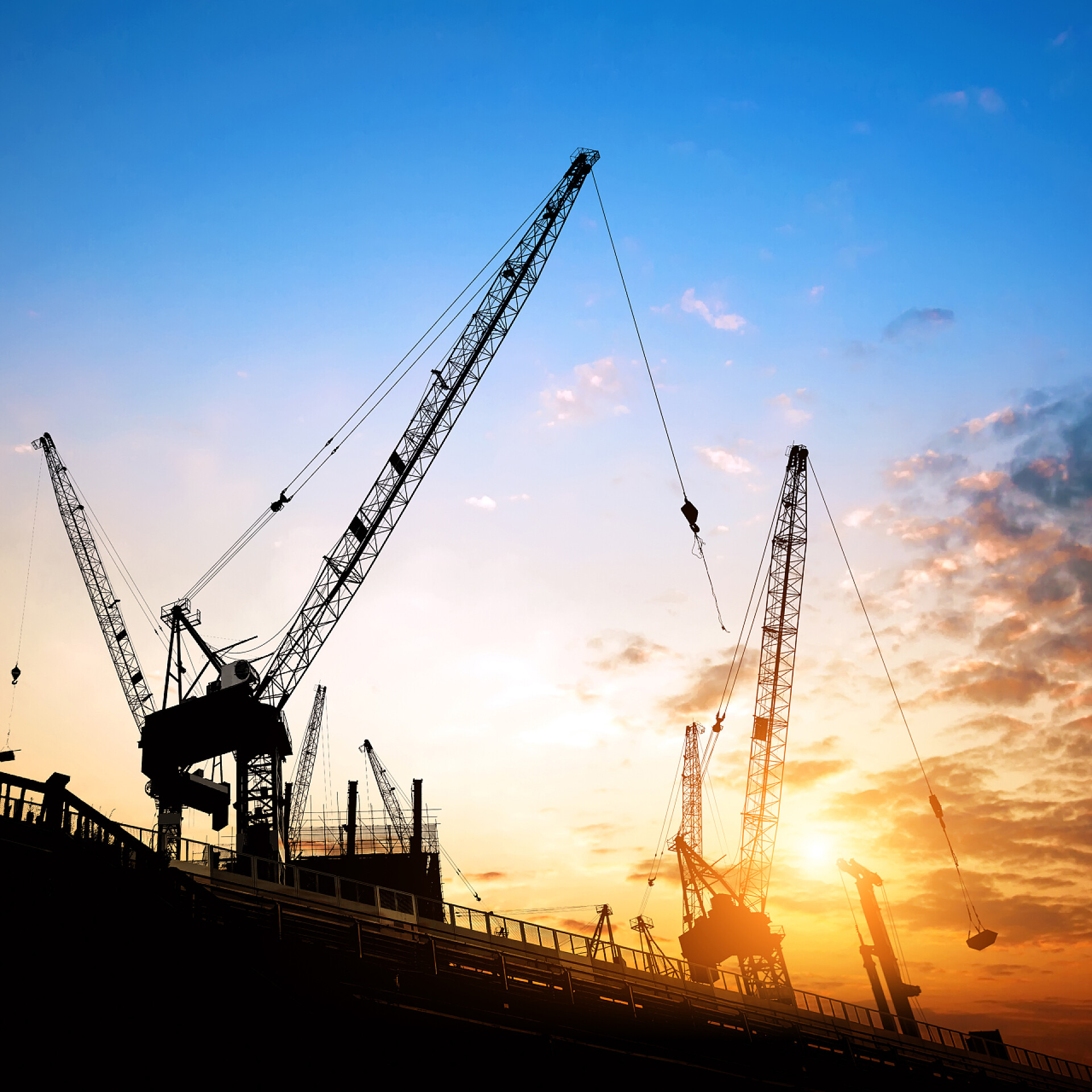 两个建筑起重机和在现场的施工人员货柜码头