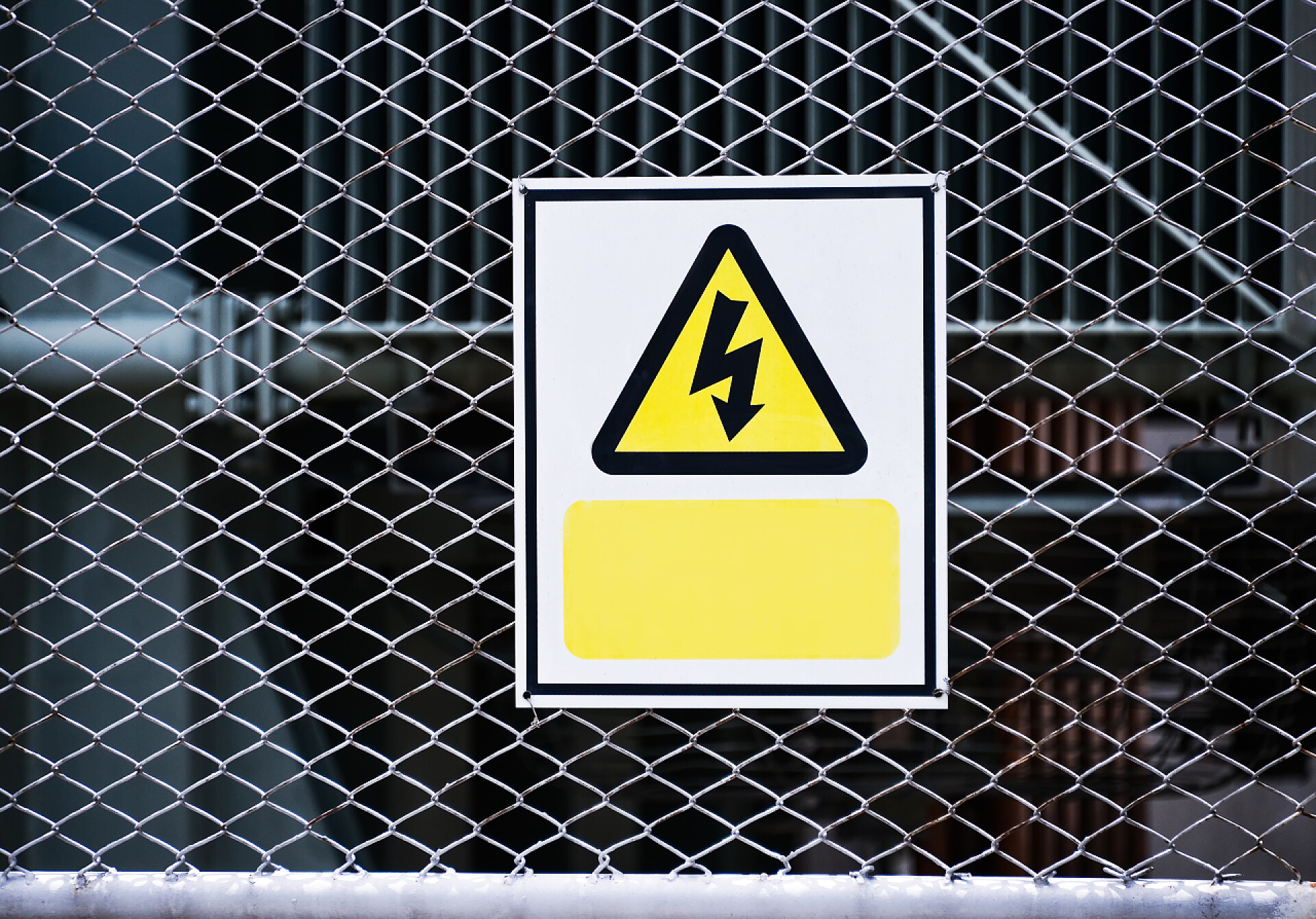 挂在铁丝网上的触电危险标志挂在铁丝网上的电气标志危险