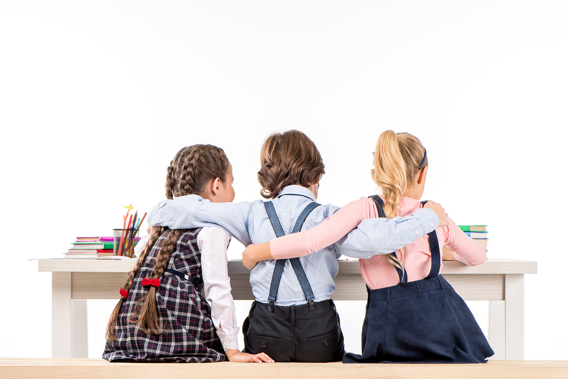 外国籍同学坐在办公桌前读书拥抱在一起同学们坐在办公桌前与书