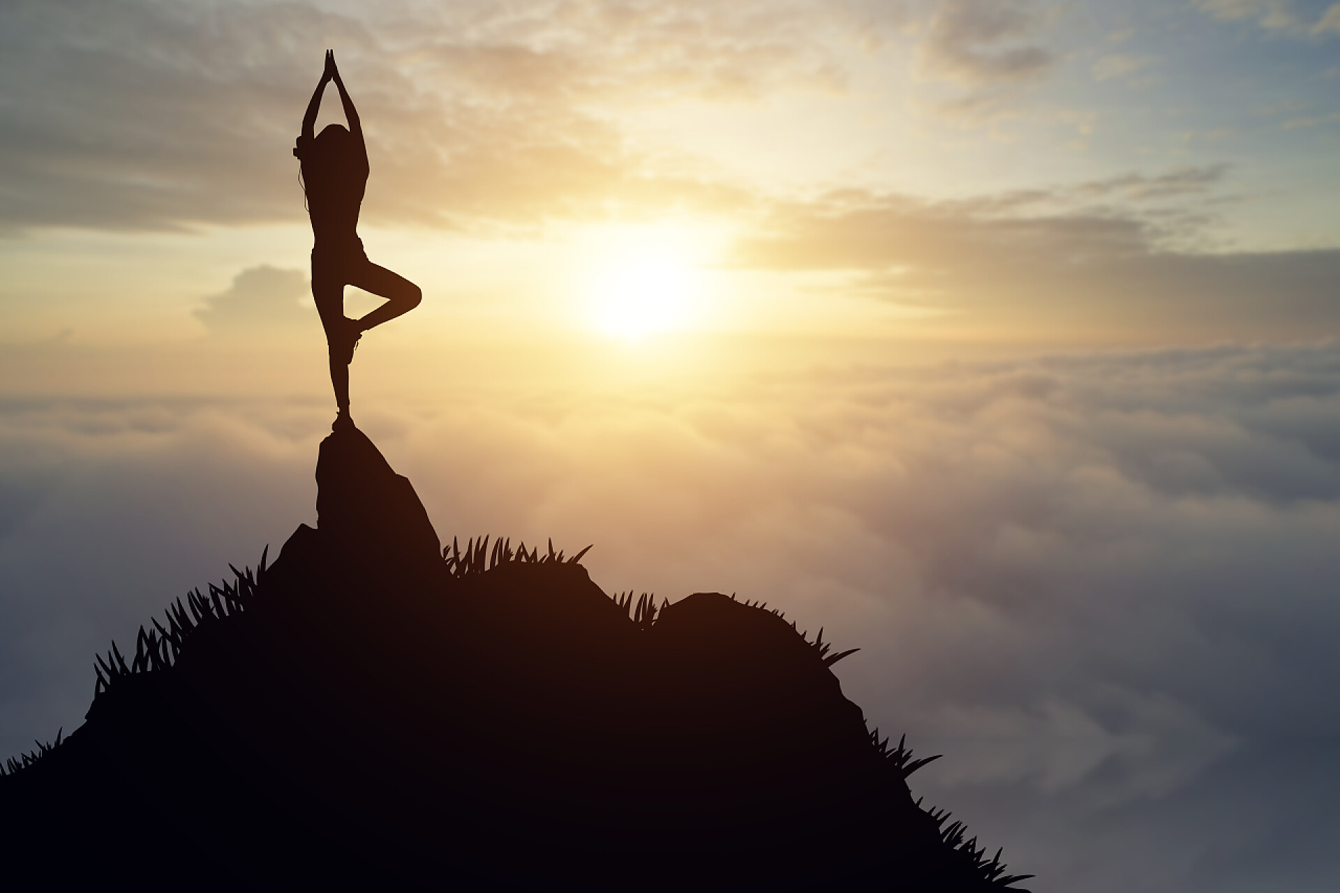 日落时在山顶上练瑜伽的女人剪影上练瑜伽的水源在日落时的剪影年轻女人