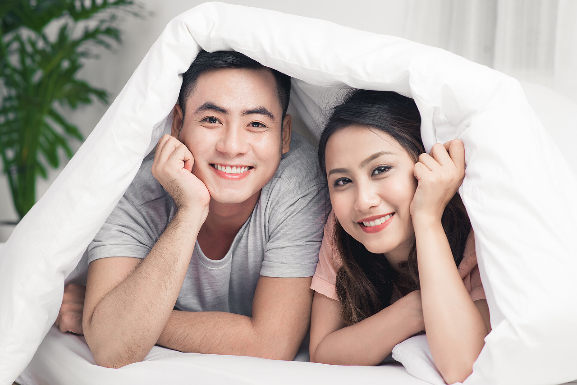 躺在床上的年轻漂亮夫妇亚洲的年轻夫妇