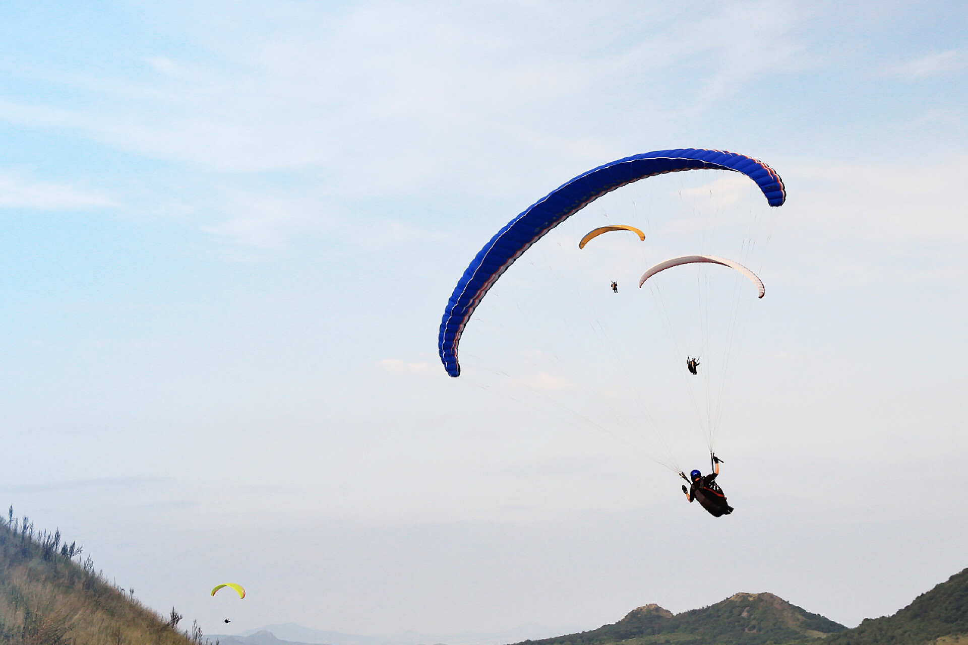 在蔚蓝的天空玩滑翔伞的人滑翔伞上天空