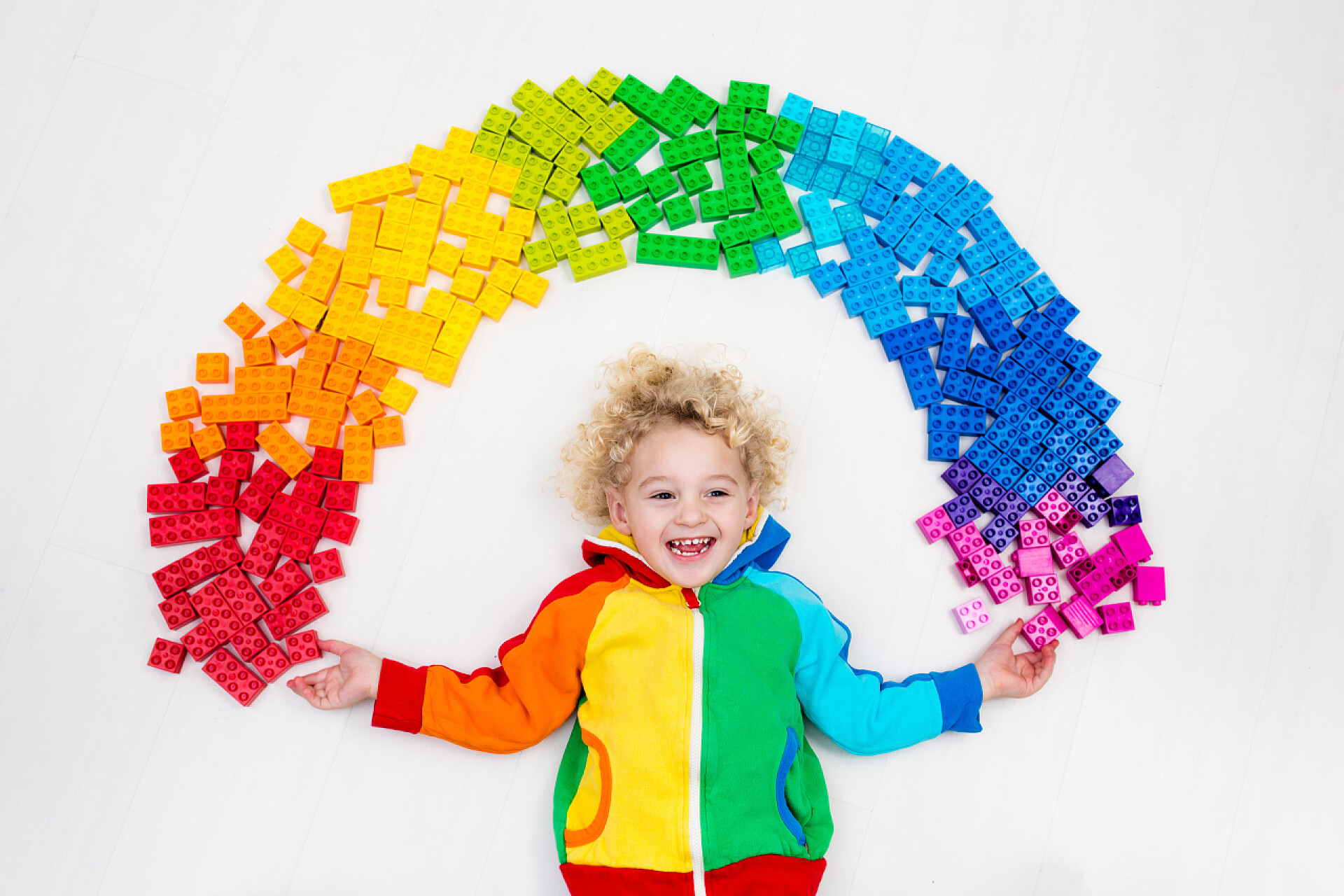 玩七彩积木的男孩小孩在玩彩虹塑料积木