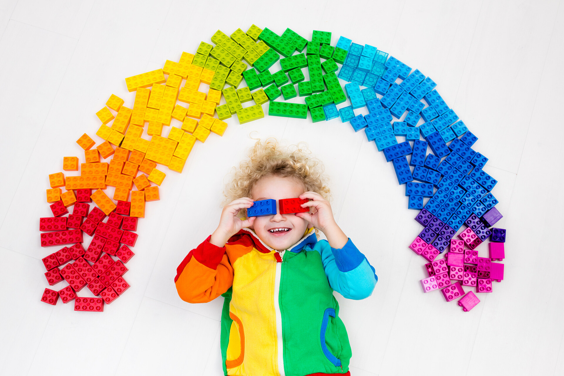 玩七彩积木的小男孩小孩在玩彩虹塑料积木