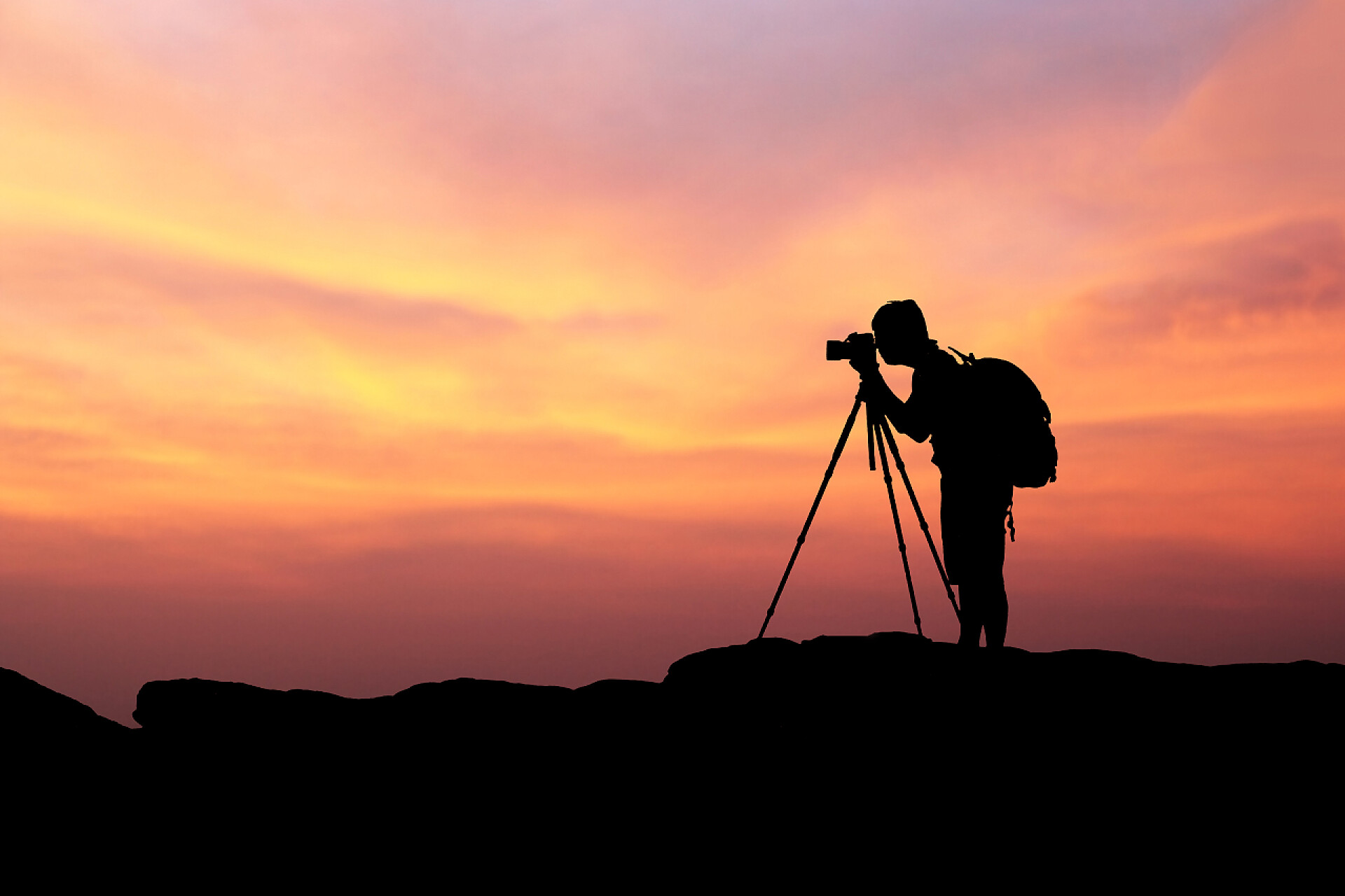 美丽的日落十分摄影师的轮廓轮廓的人摄影、 拍照与山在一元