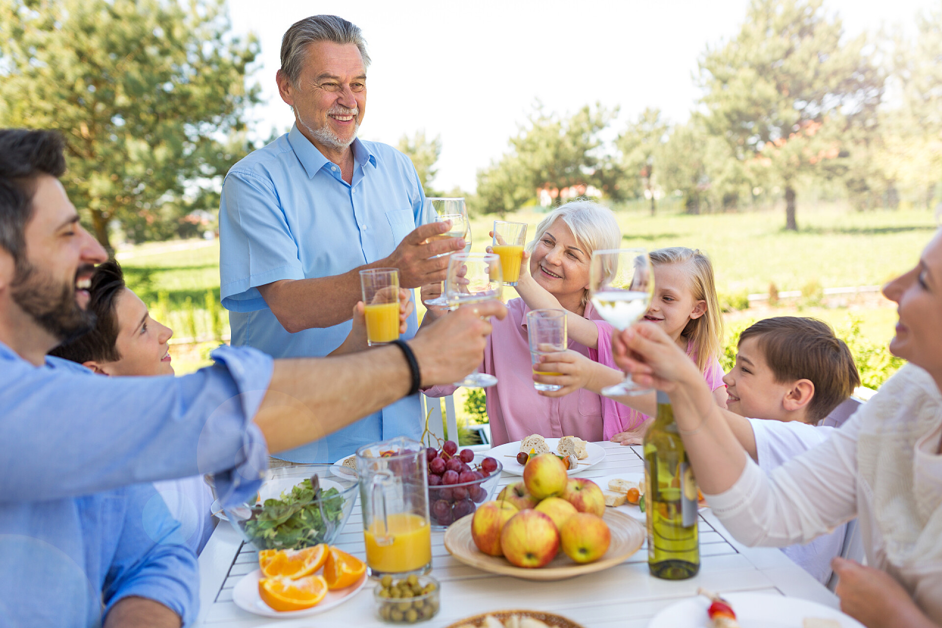 家庭坐在花园里开心聚餐大家庭在户外吃
