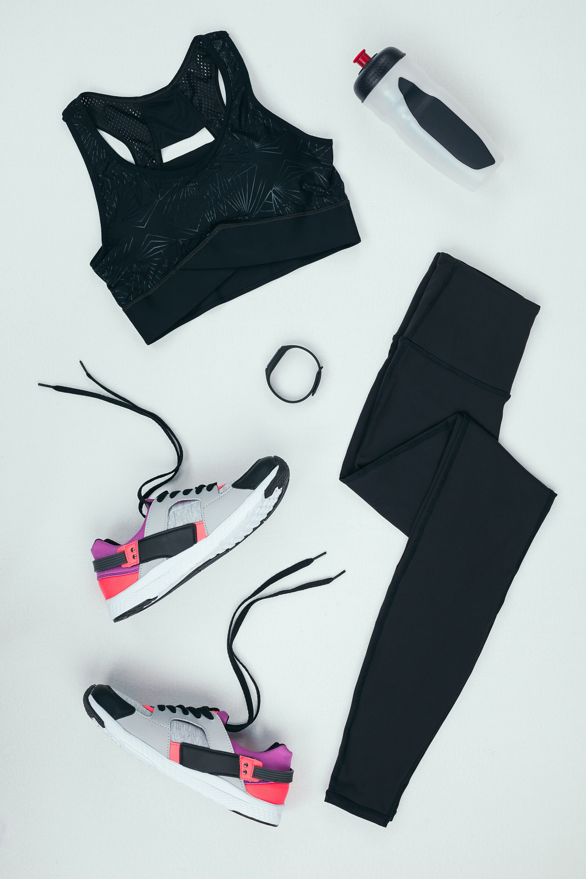 平躺的黑色运动服运动鞋健身器材运动服运动鞋，一瓶 