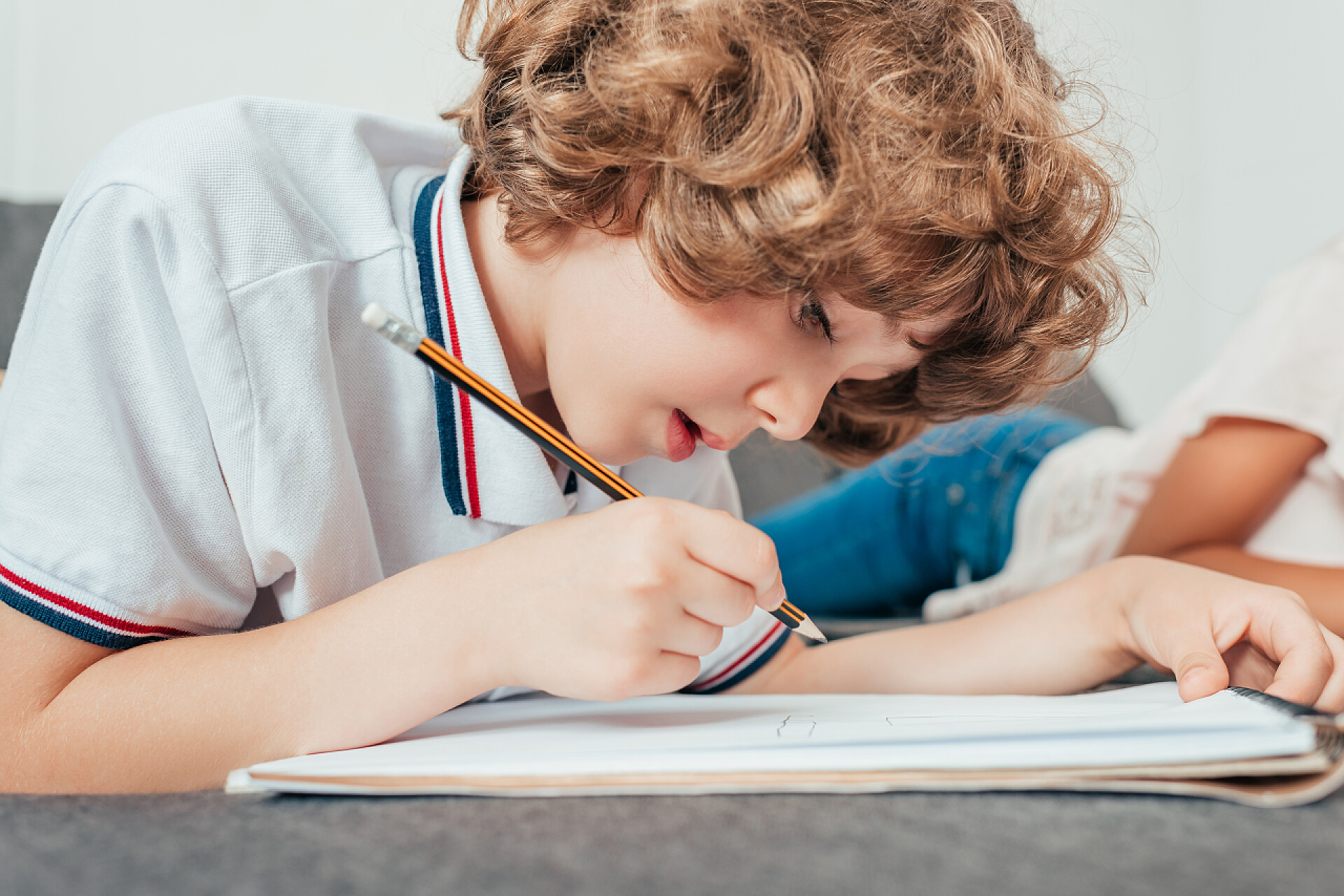 可爱卷发的小男孩做家庭作业家庭作业