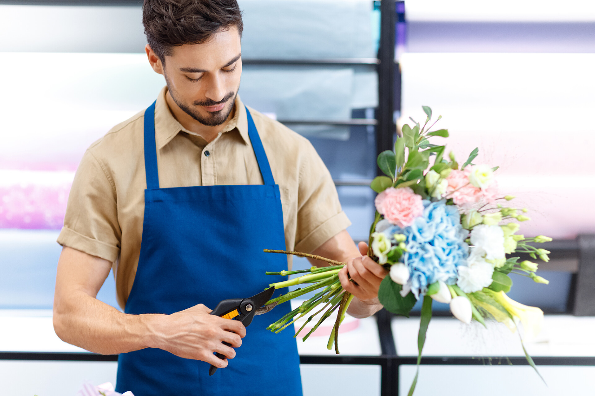 男人戴着围裙修剪花束花店切花