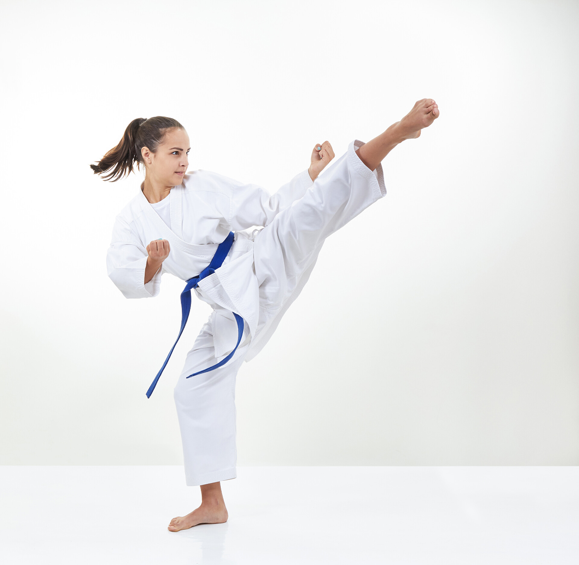 白色背景上蓝带运动员训练踢腿蓝带运动员训练踢