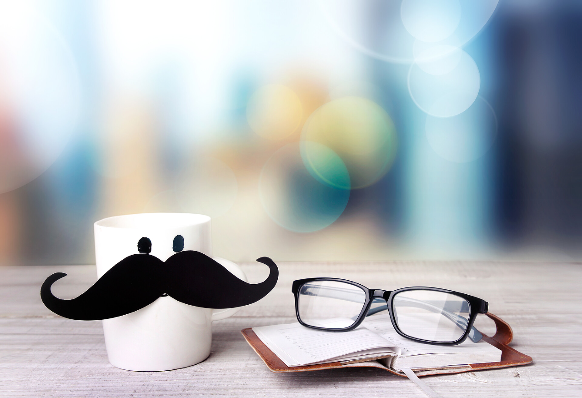 光晕背景下的办公室桌咖啡和眼镜父亲节。办公饮料概念.